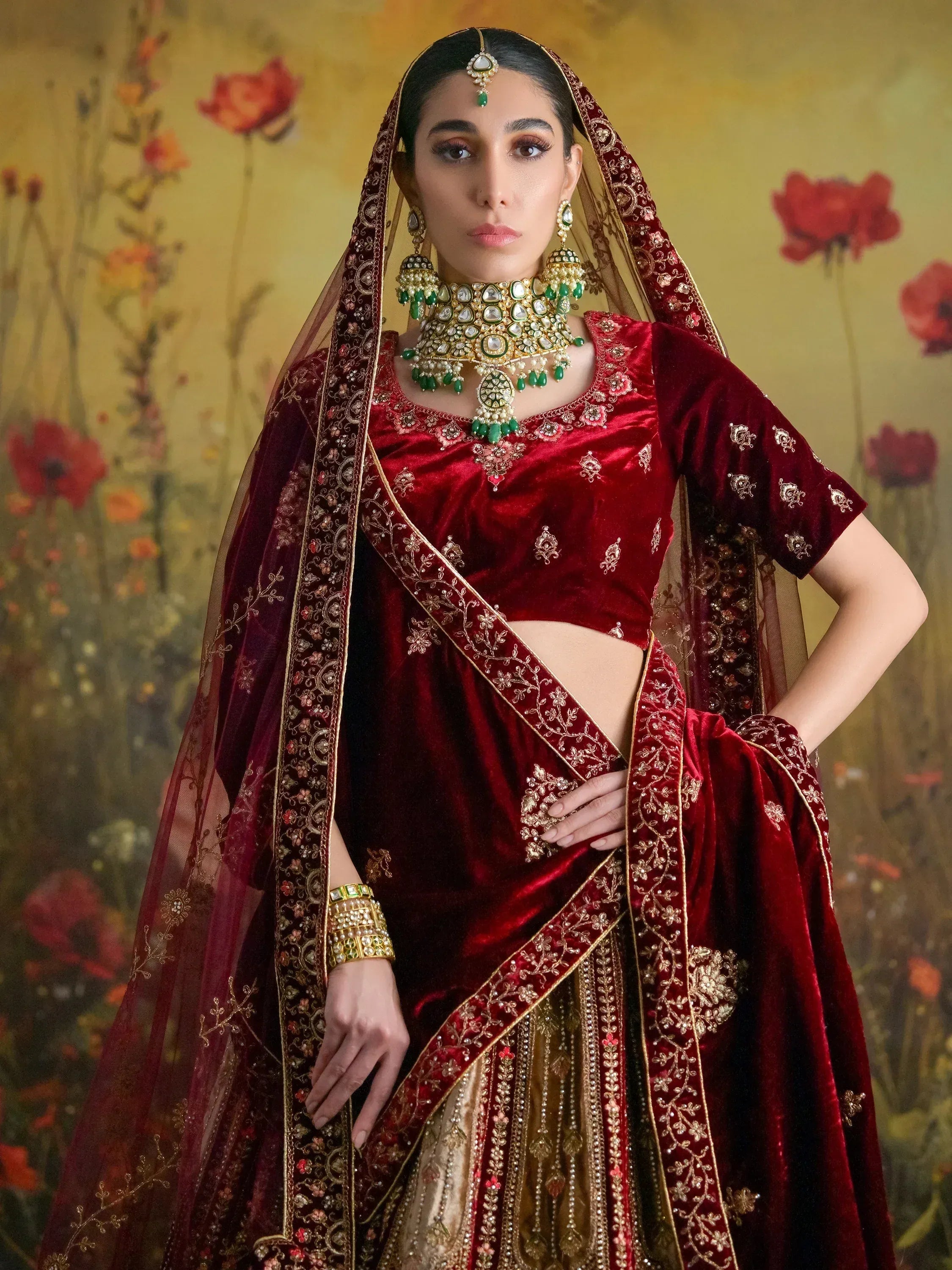 Red velvet lehenga choli with gold embroidery and green jewelry, Indian ethnic wear