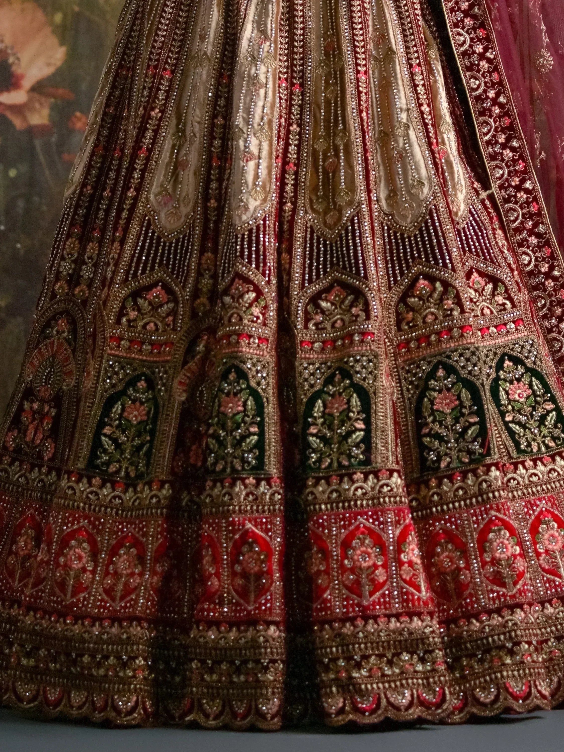 Luxury red and gold embroidered lehenga with intricate floral and beadwork details for Indian weddings