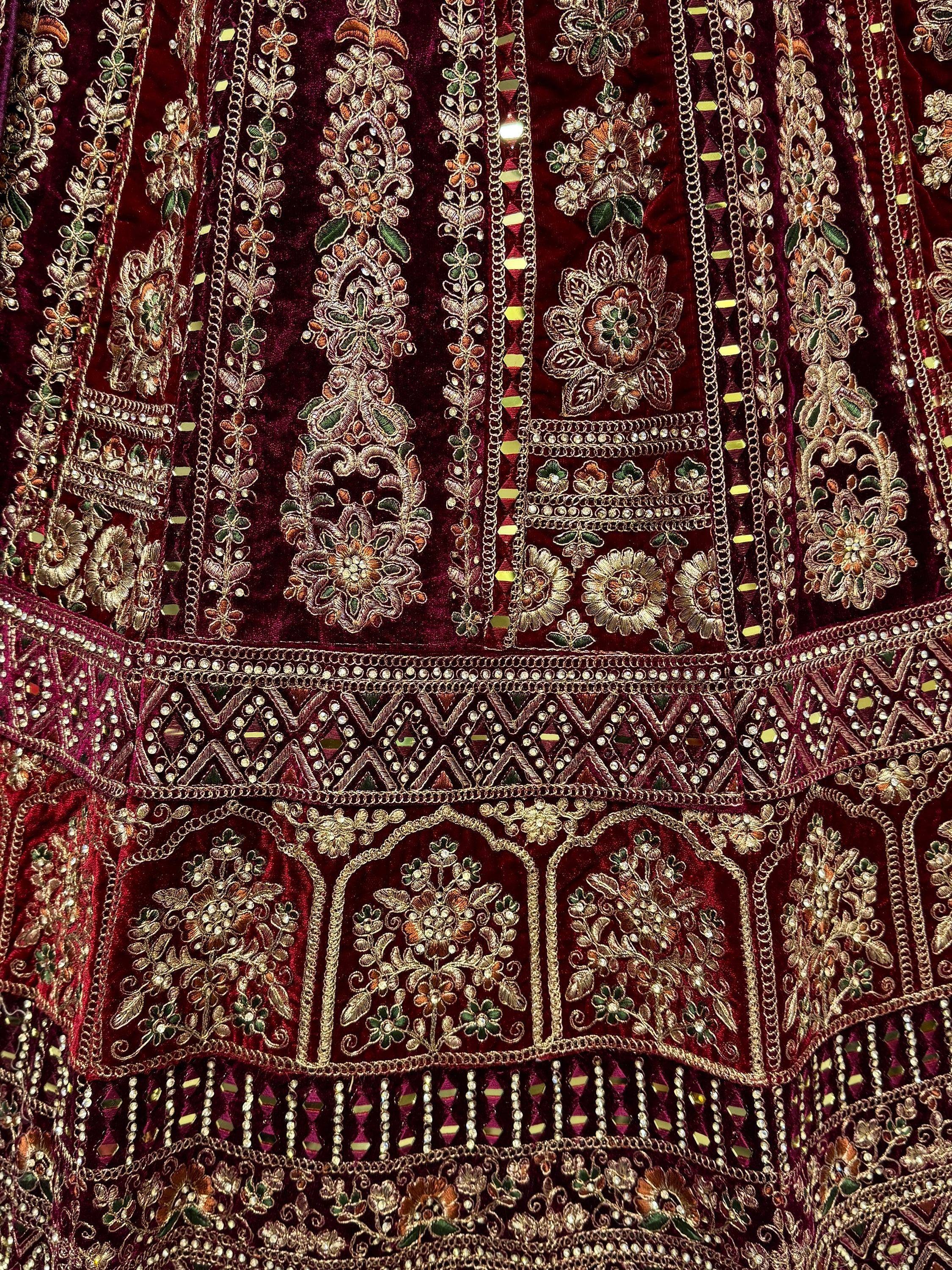 Luxury maroon velvet lehenga with intricate gold floral embroidery and mirror work details