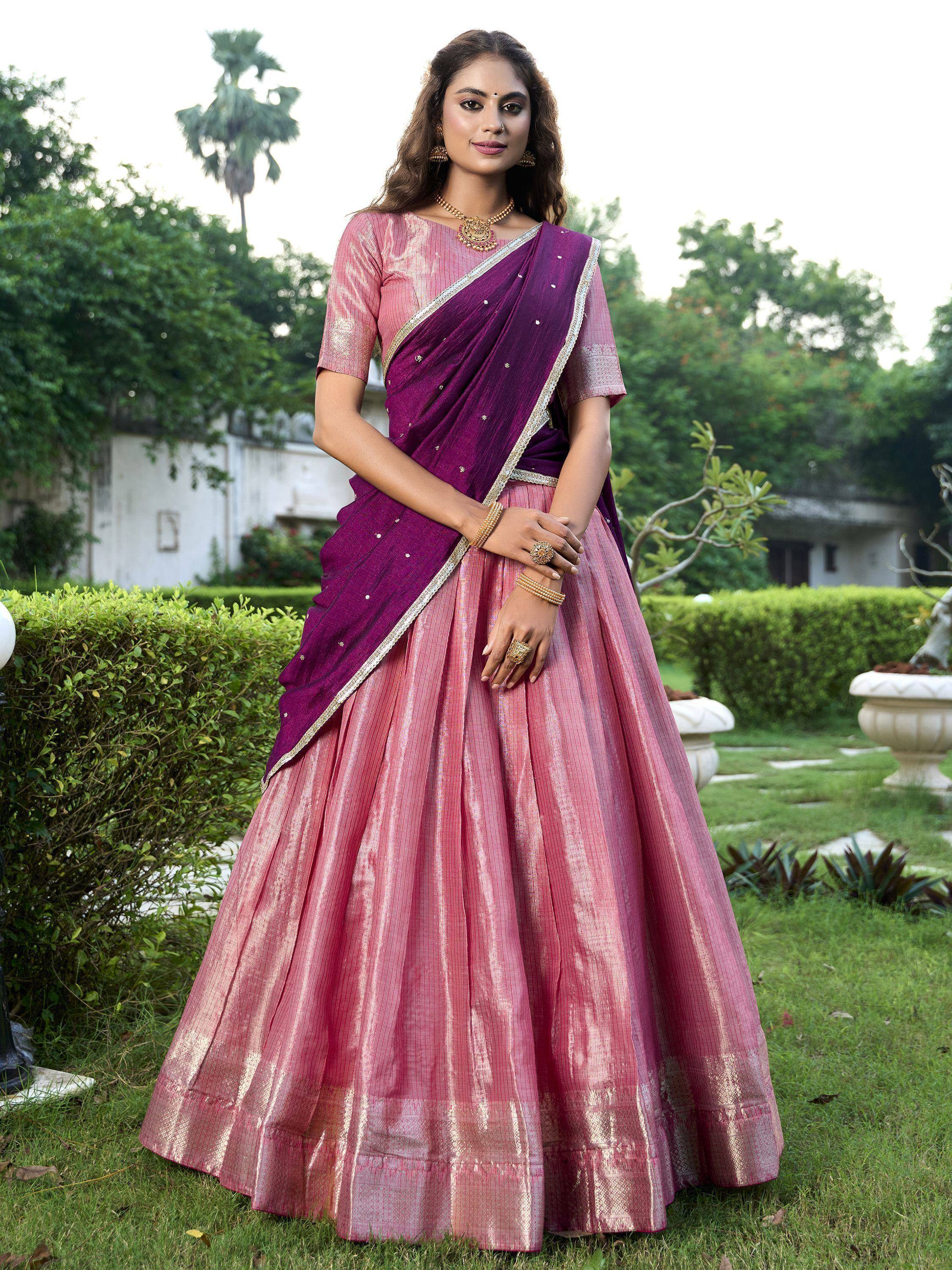 Woman in pink and purple designer lehenga choli with gold embroidery, perfect for Indian ethnic wear occasions.