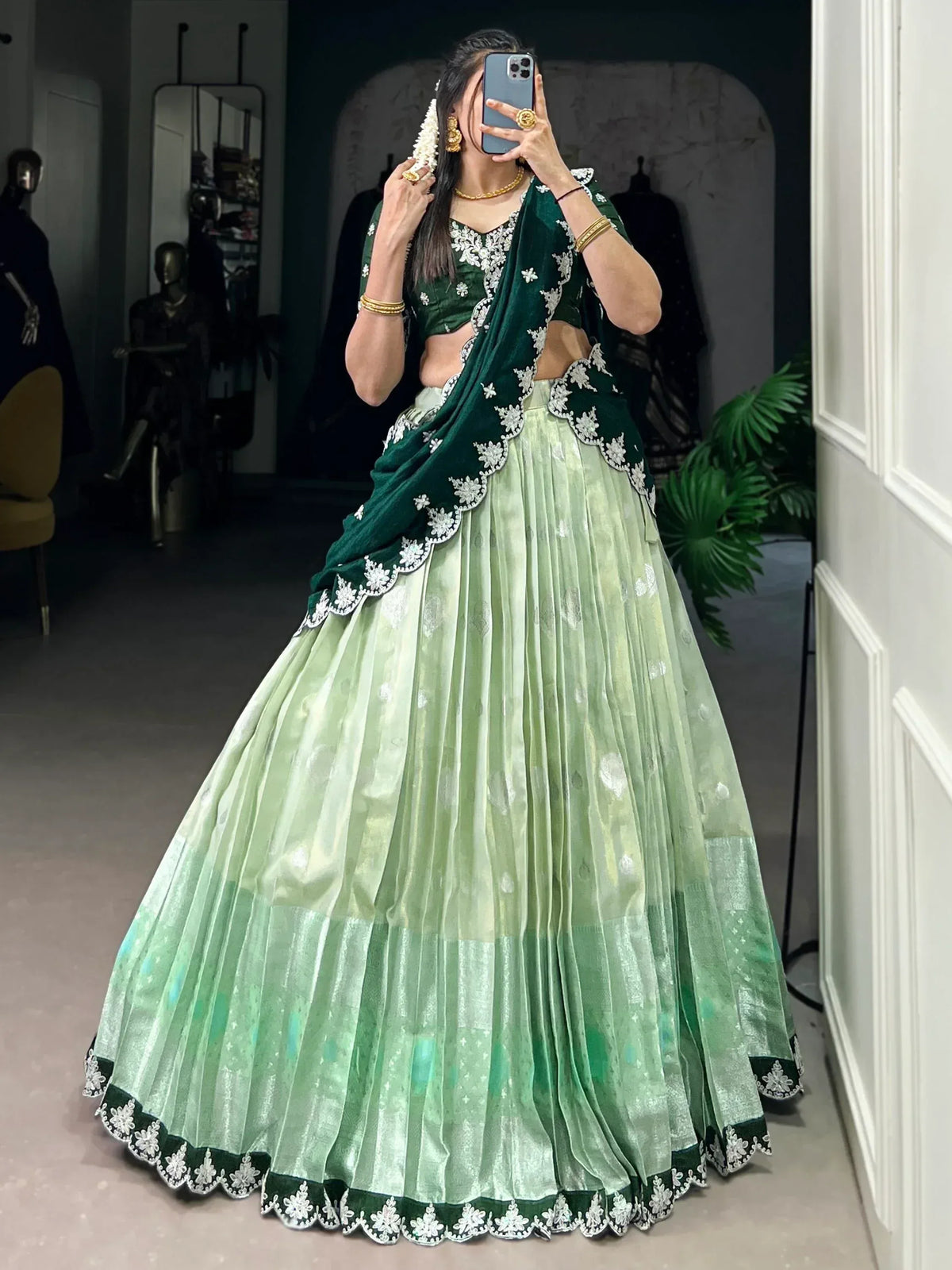 Green velvet lehenga choli with white embroidery, perfect for Indian weddings and festive occasions.