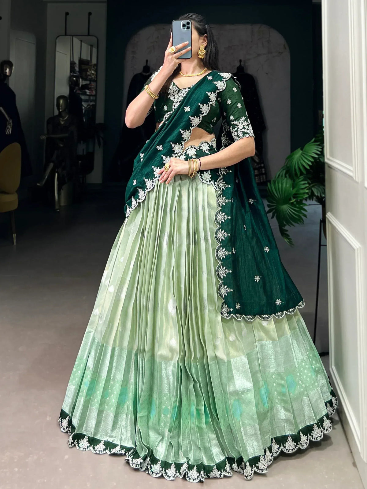Emerald green lehenga choli with white floral embroidery, pleated skirt, and matching dupatta for Indian ethnic wear