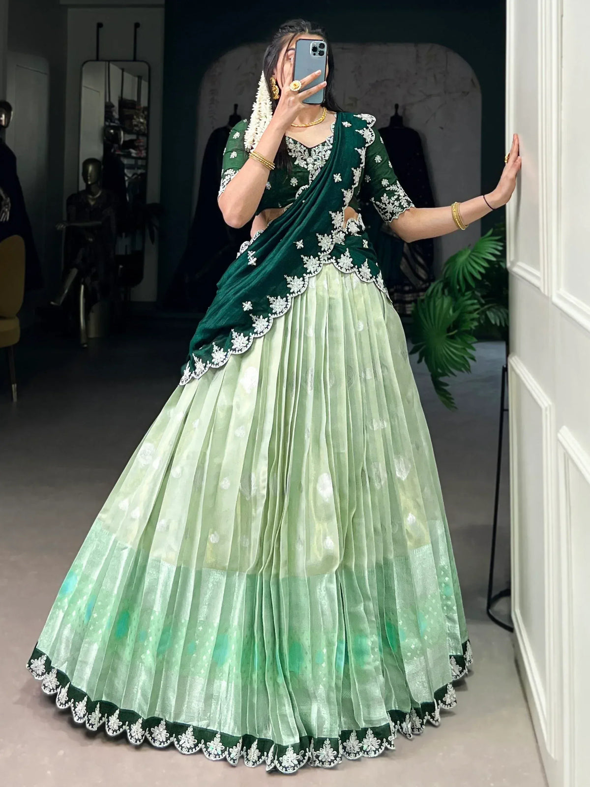 Emerald green lehenga choli with white floral embroidery, pleated skirt, perfect for Indian weddings and festive occasions.
