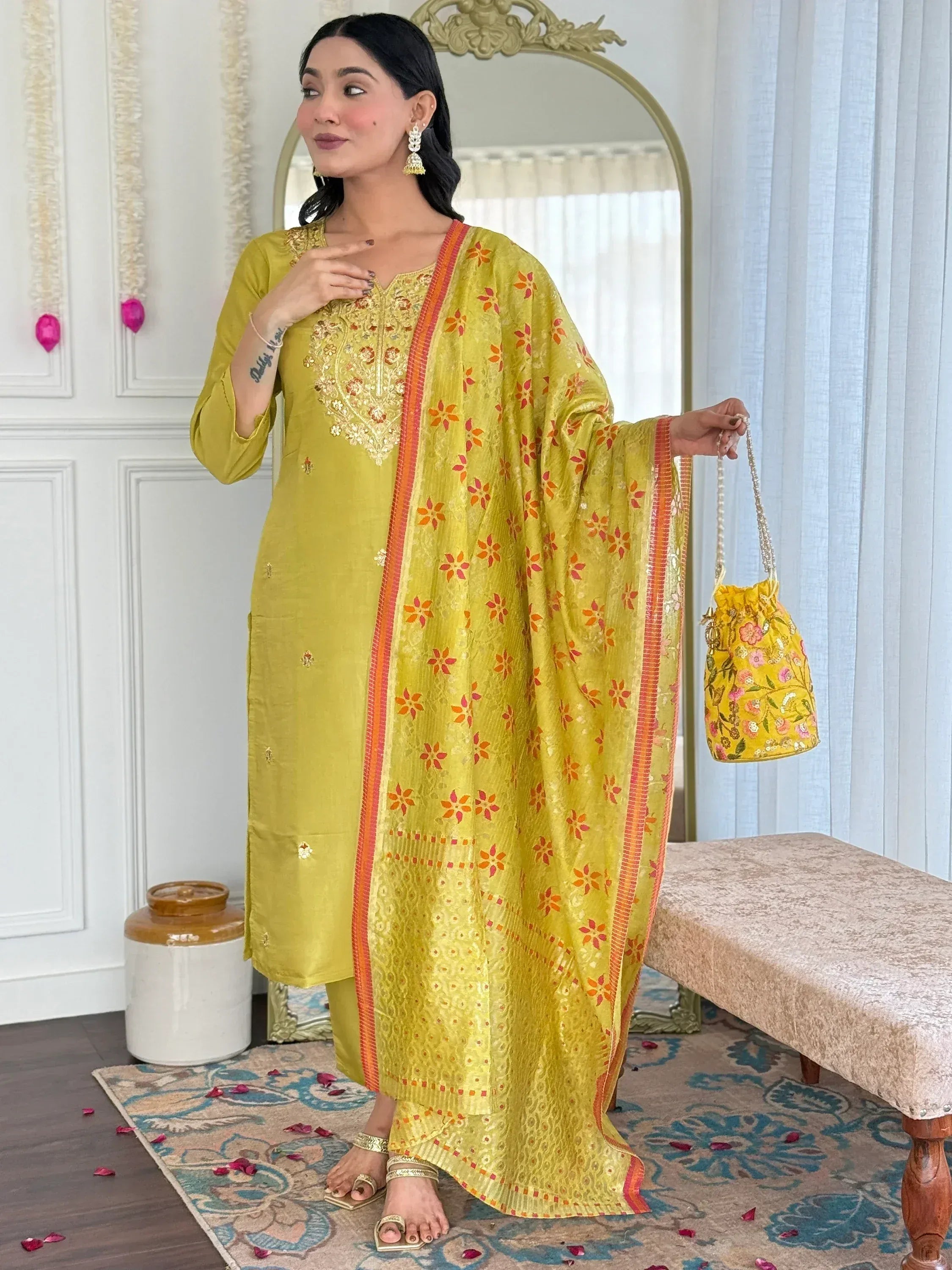 Yellow embroidered salwar kameez with floral dupatta and matching potli bag, perfect for ethnic occasions