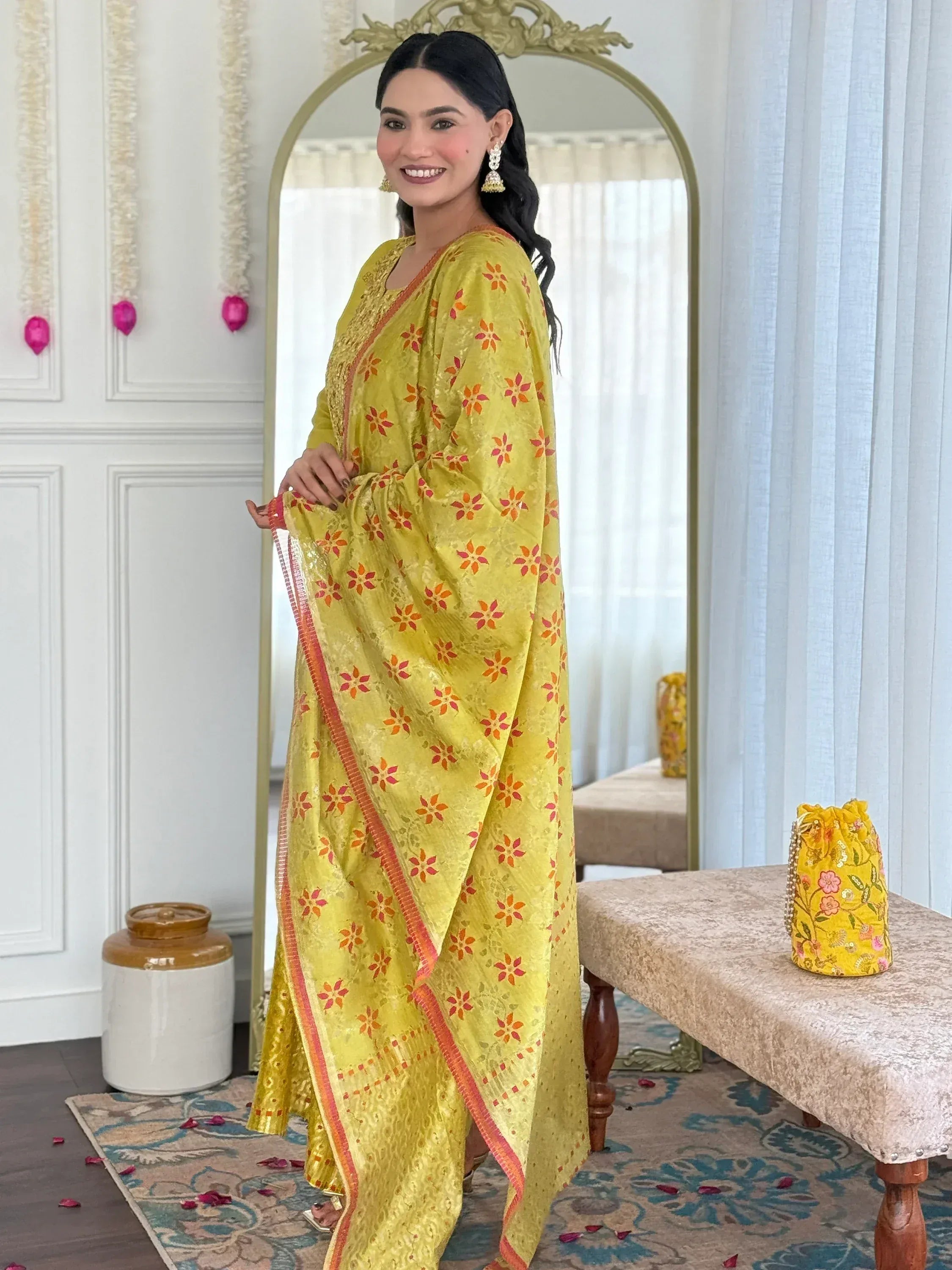 Yellow floral ethnic gown with orange accents, perfect for festive occasions and traditional events.