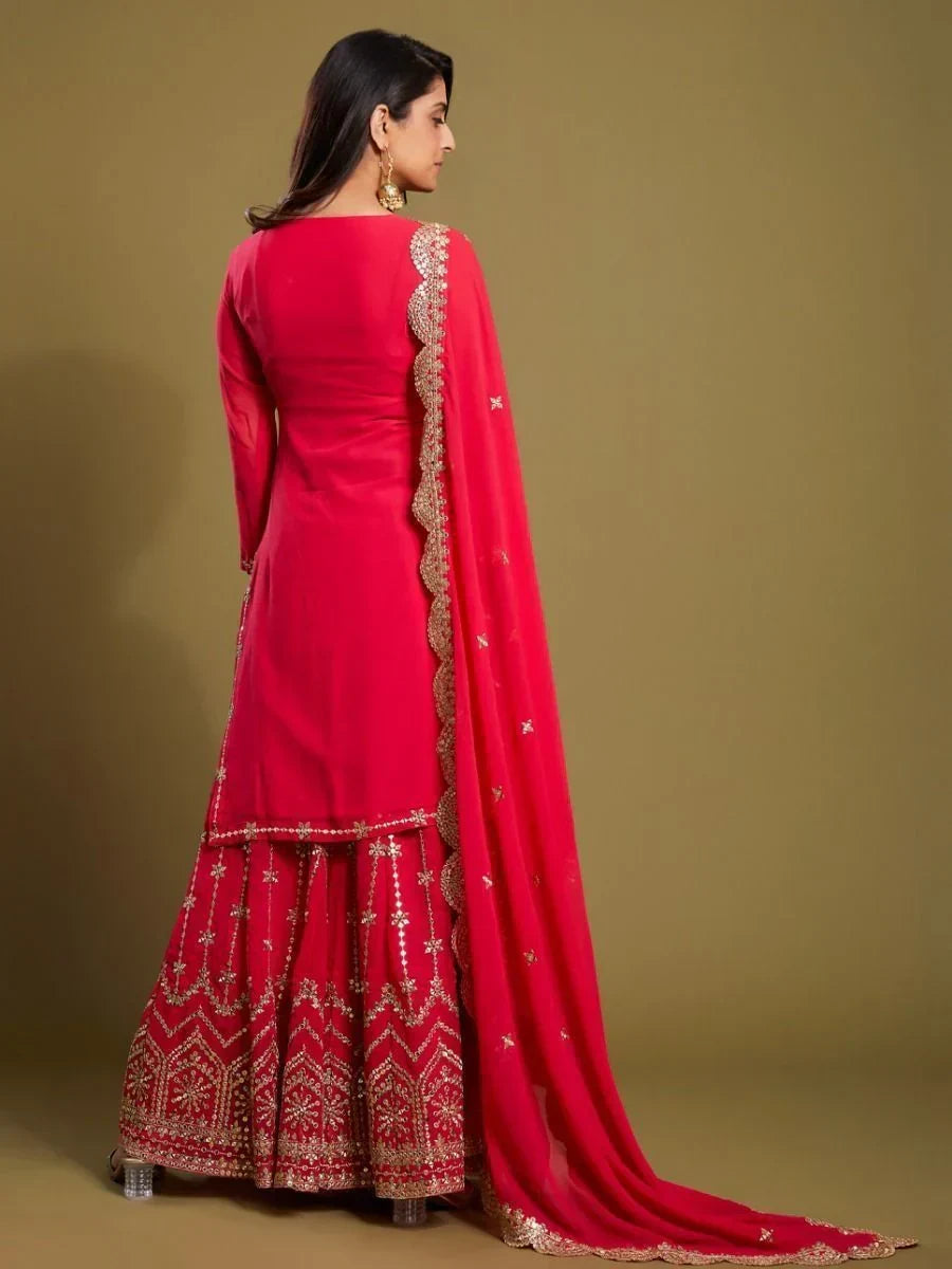 Woman in a red embroidered ethnic suit with dupatta, showcasing Indian festive wear