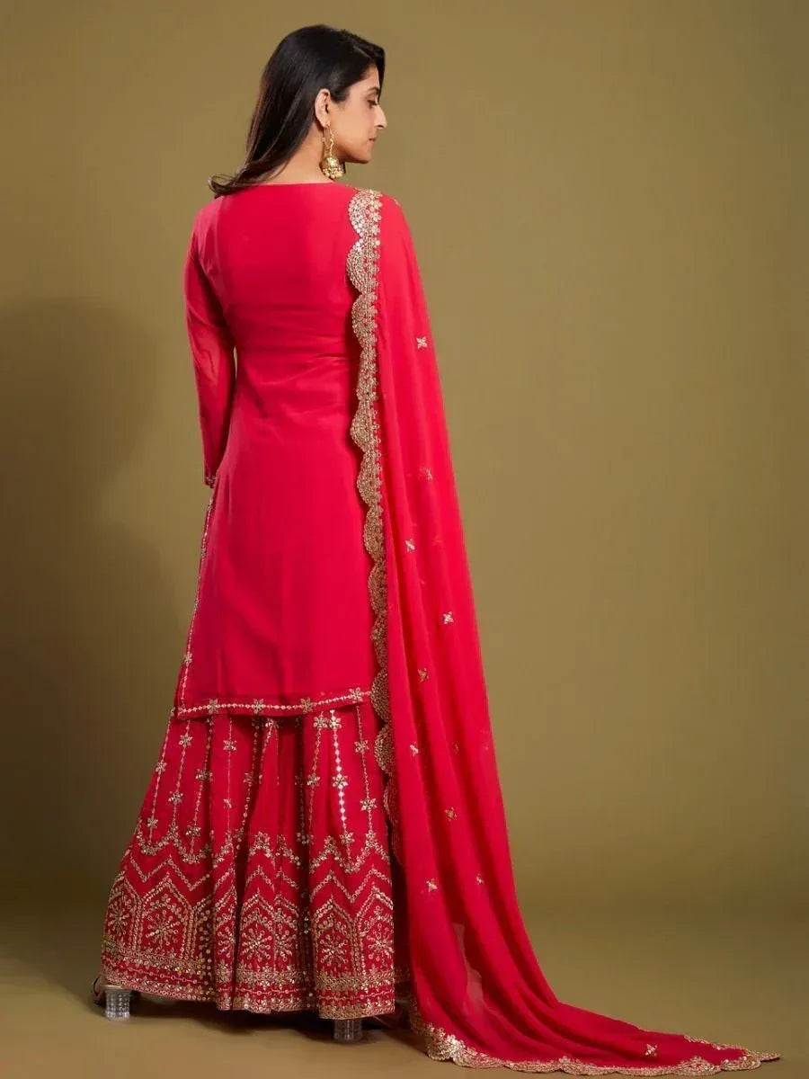 Woman in a red embroidered ethnic suit with dupatta, showcasing Indian festive wear