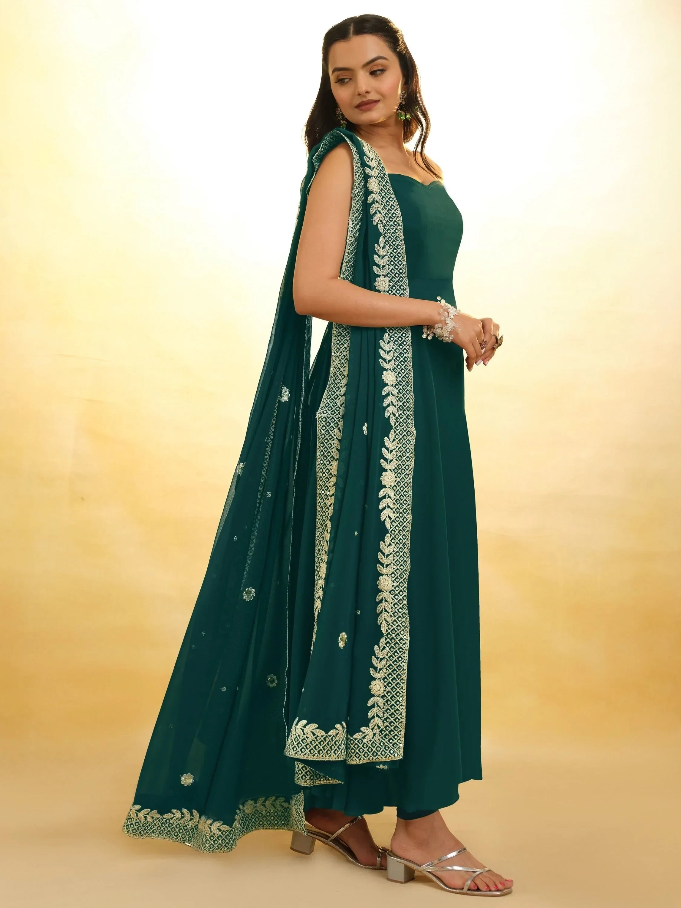 Woman wearing teal Indian ethnic gown with embroidered dupatta and silver heels