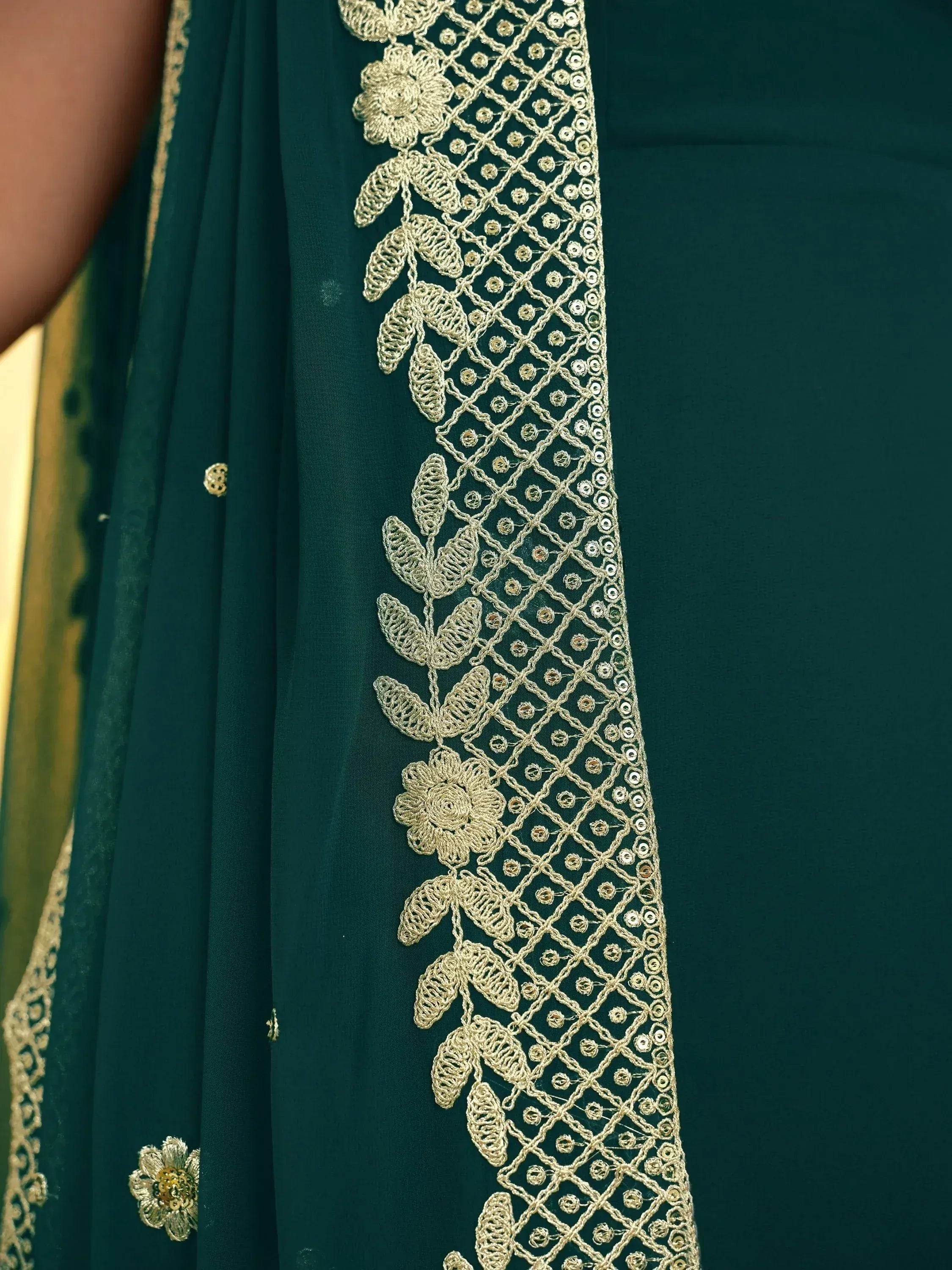 Emerald green ethnic gown with gold floral embroidery and sequin detailing for festive occasions