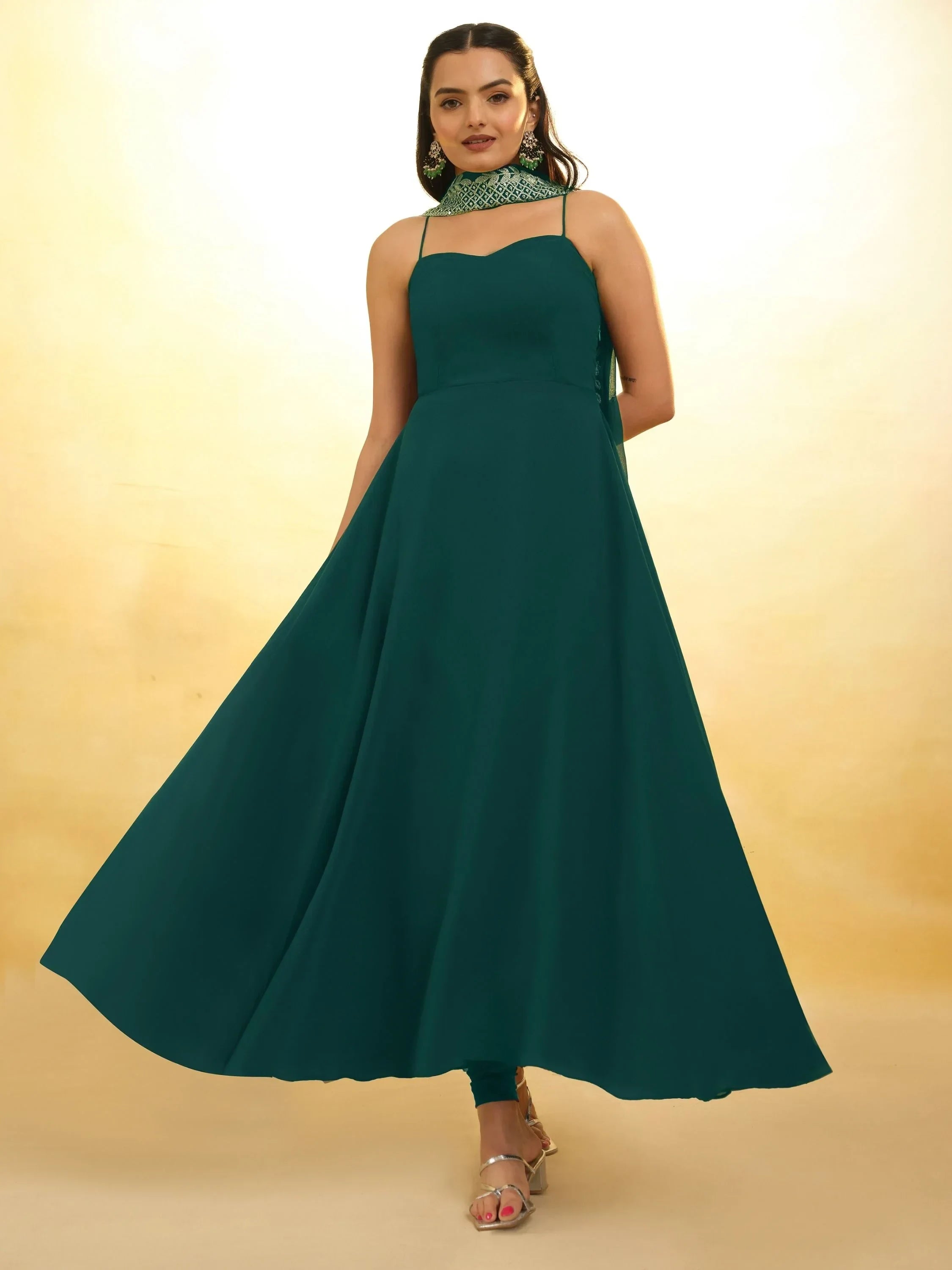 Woman in a teal sleeveless ethnic gown with flared skirt and patterned dupatta