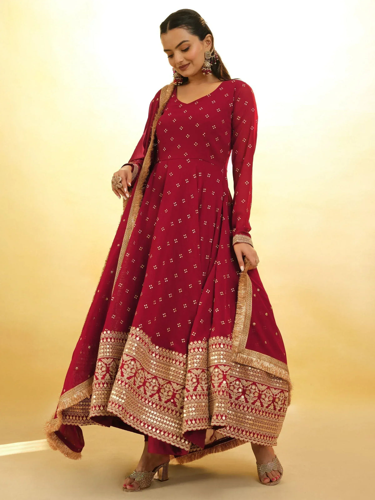 Maroon ethnic anarkali gown with gold embroidery and sequin border, perfect for Indian weddings and festive occasions.