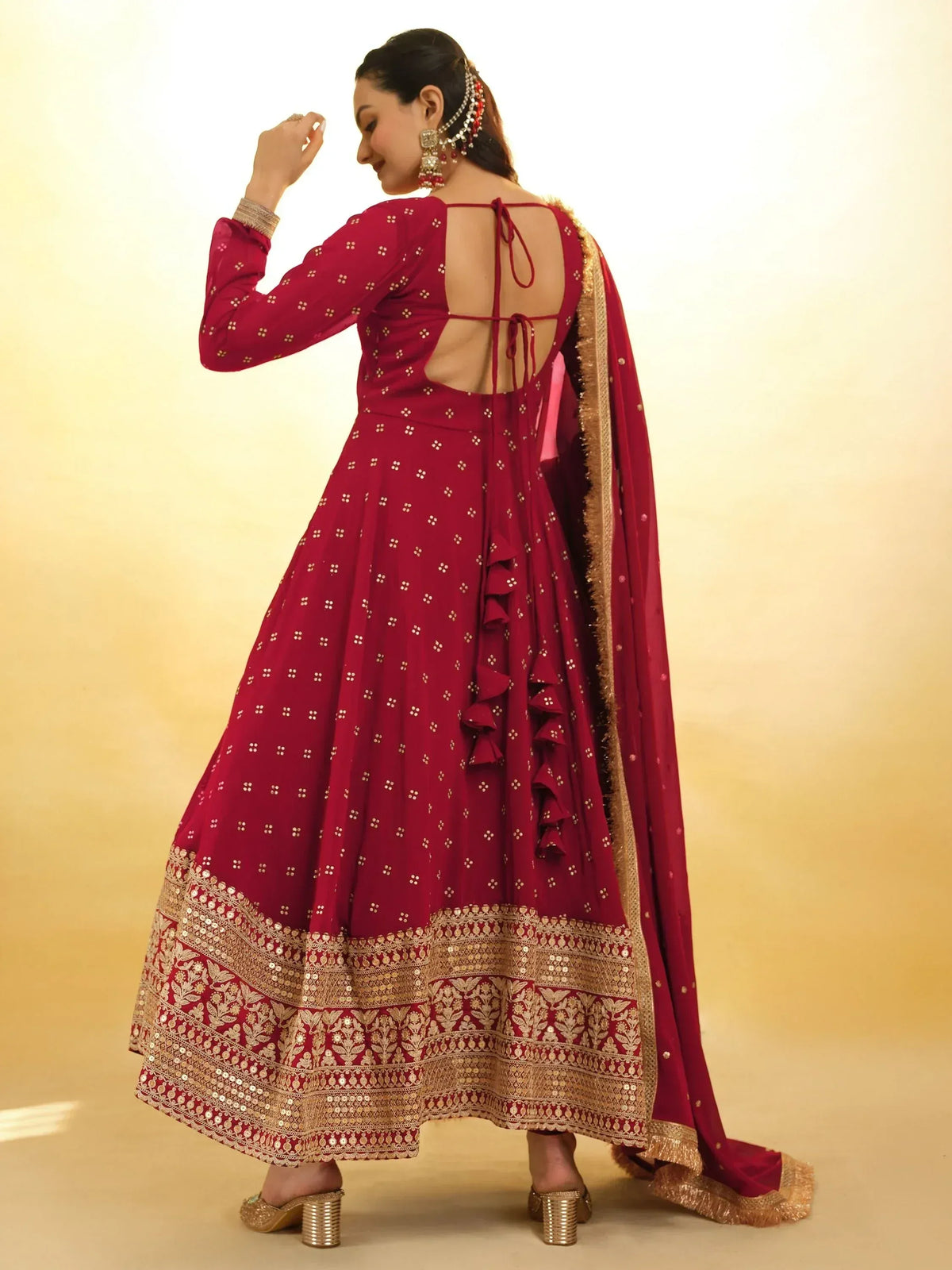 Maroon designer lehenga choli with gold embroidery, back tie detail, and ruffled dupatta for Indian ethnic wear