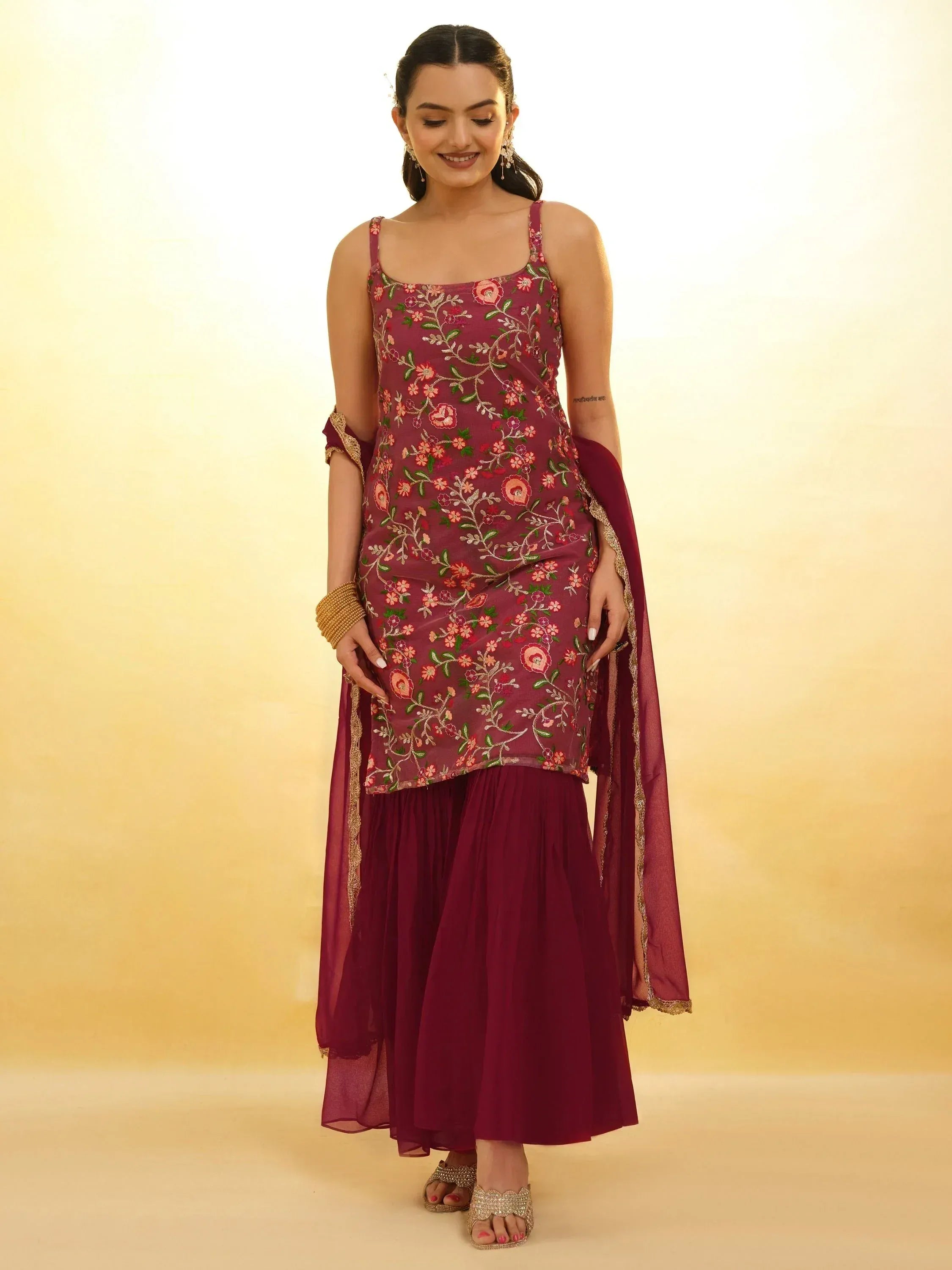Woman wearing maroon floral embroidered sharara suit with dupatta, festive ethnic wear