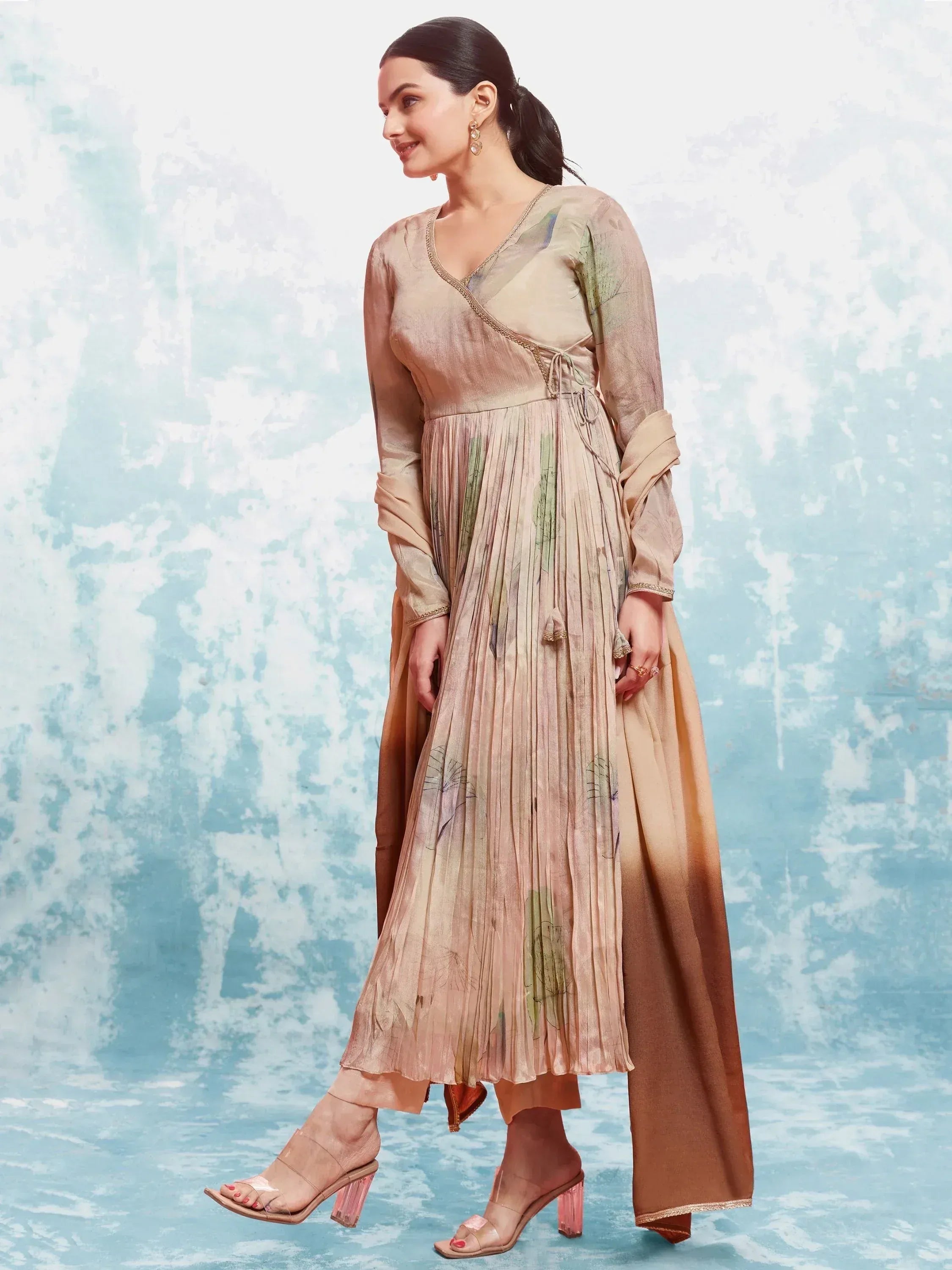 Beige floral print pleated ethnic gown with V-neck and side slit, paired with palazzo pants and heels