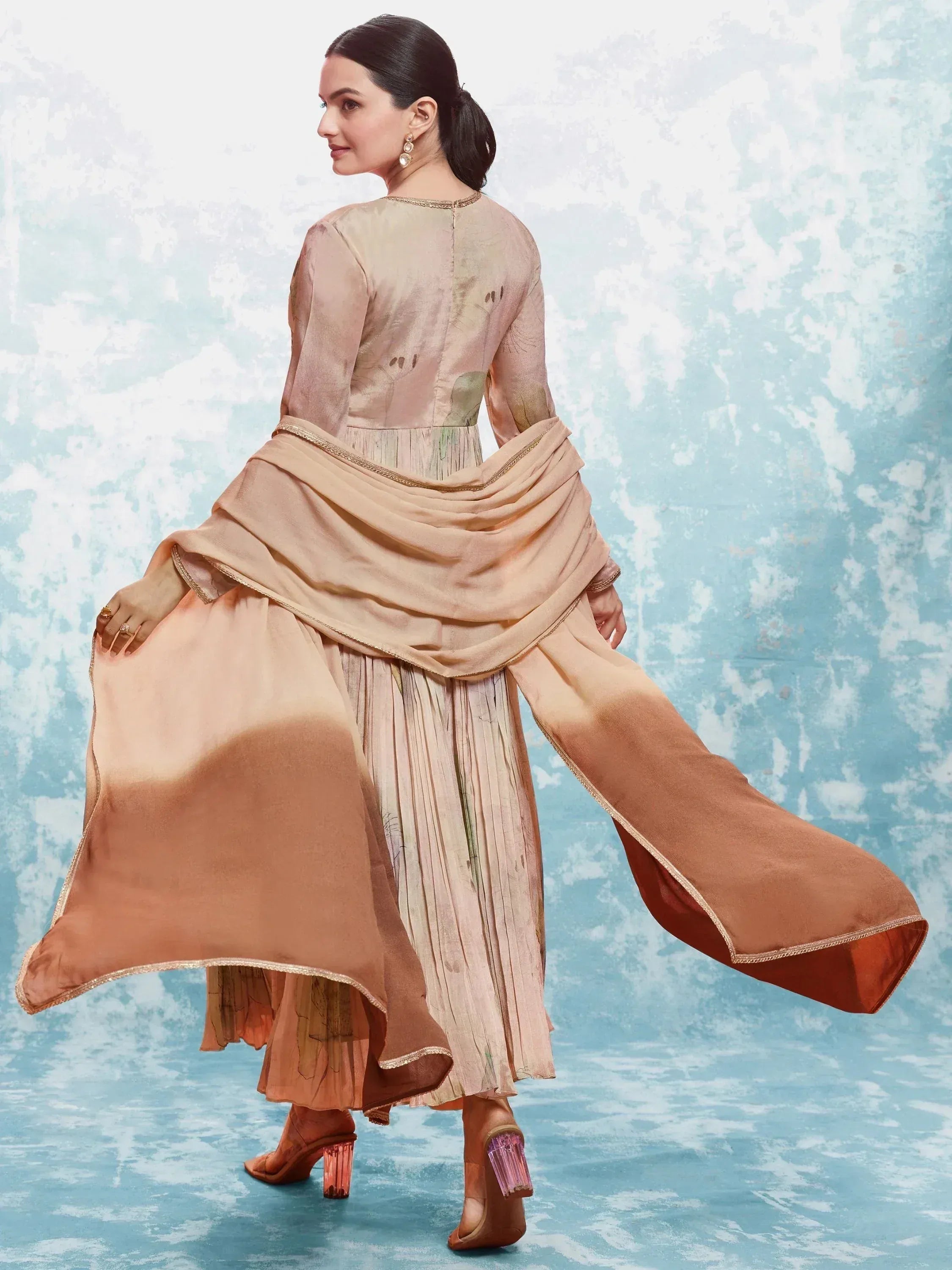 Elegant peach ethnic gown with pleated skirt and dupatta, perfect for Indian occasions