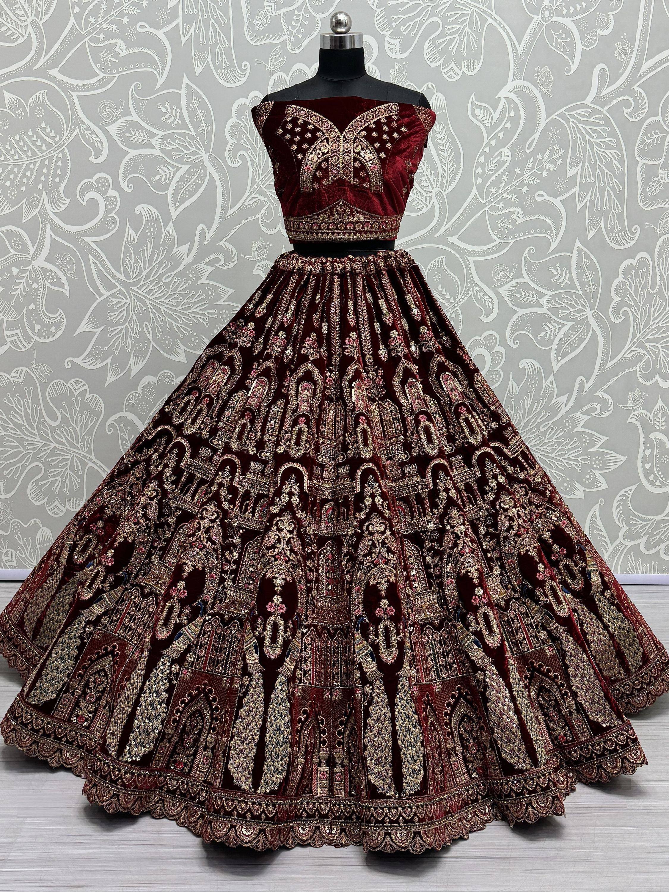 Maroon velvet lehenga choli with heavy gold embroidery, perfect for weddings and festive occasions.
