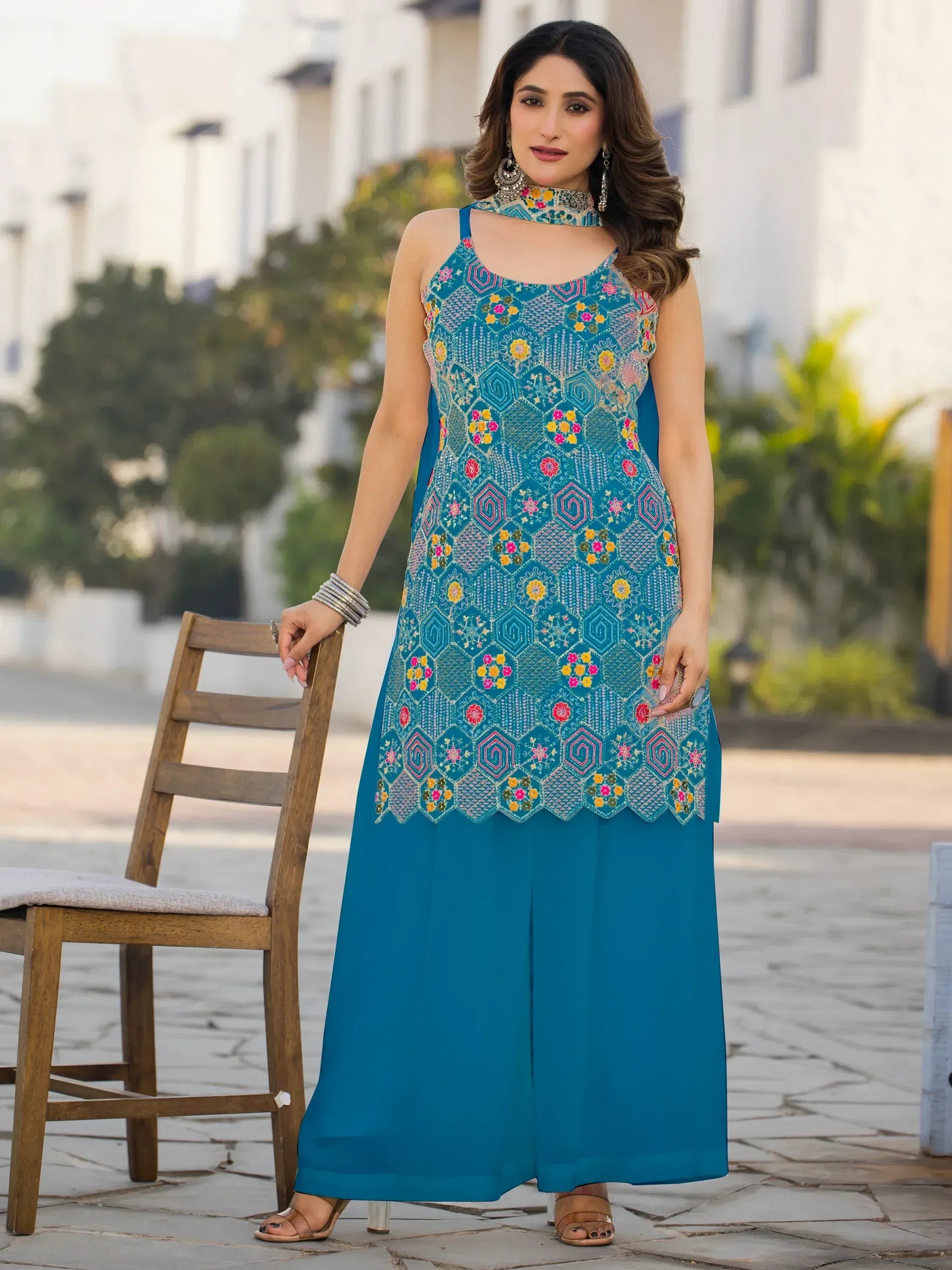 Teal embroidered ethnic gown with floral patterns and matching choker, styled for Indian wear