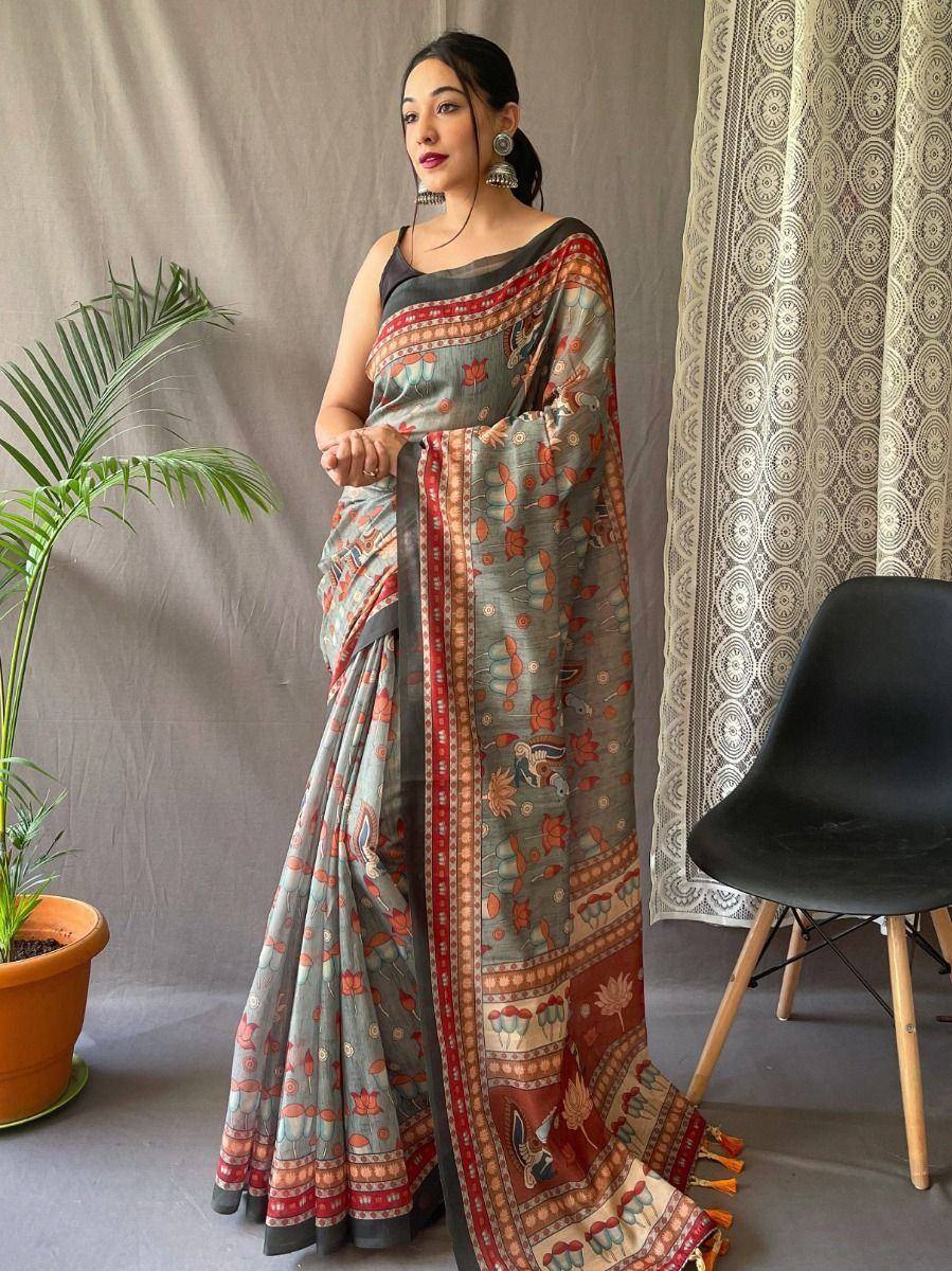 Woman in printed ethnic saree with floral and elephant motifs, styled with black blouse and statement earrings