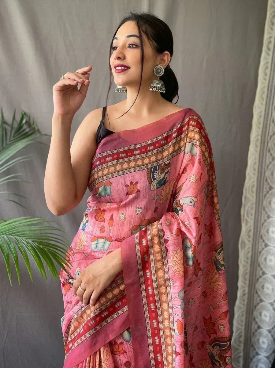 Pink printed saree with floral and bird motifs, paired with black blouse and jhumka earrings