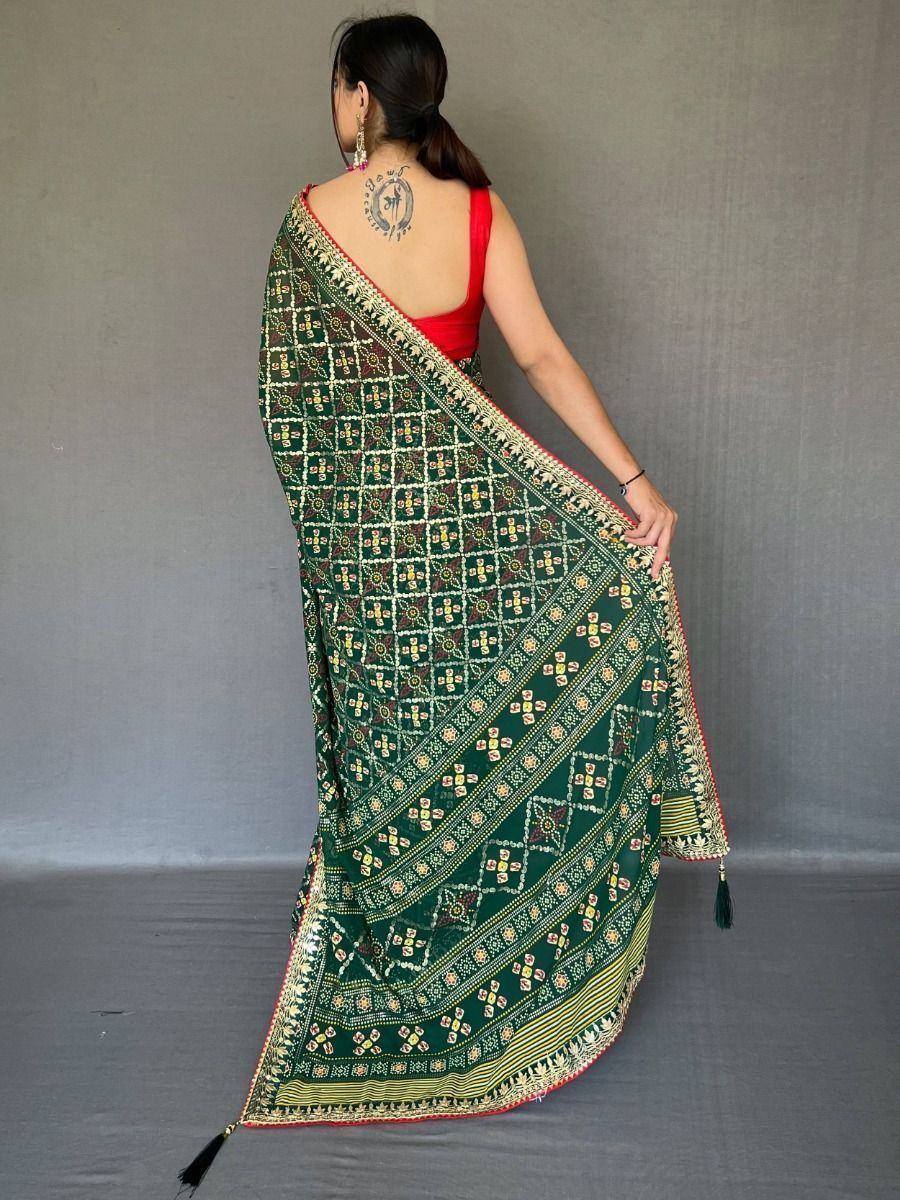 Green printed saree with gold border and tassels, paired with red blouse, ethnic wear