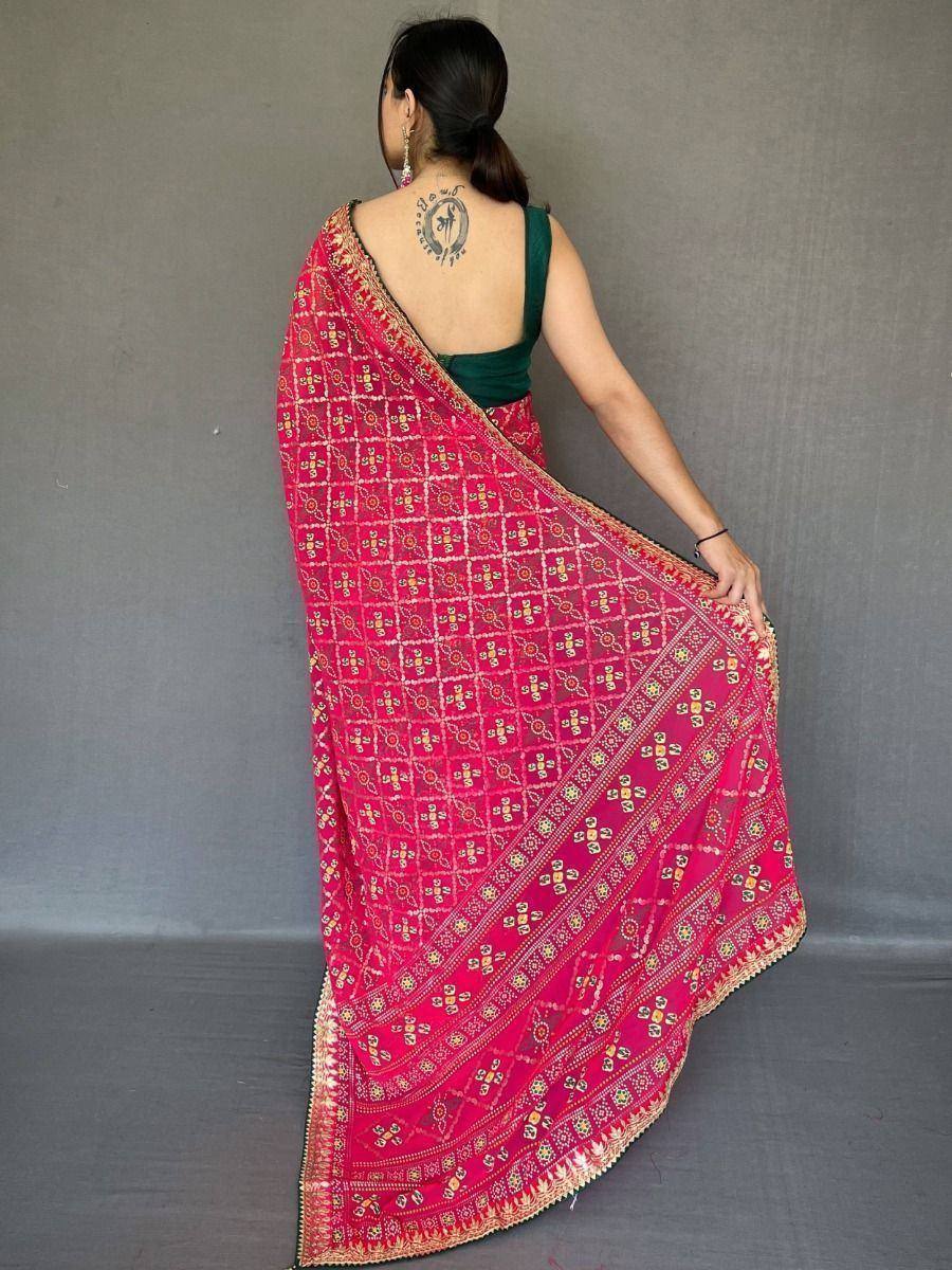 Vibrant pink printed saree with intricate patterns and golden border, paired with a green blouse.