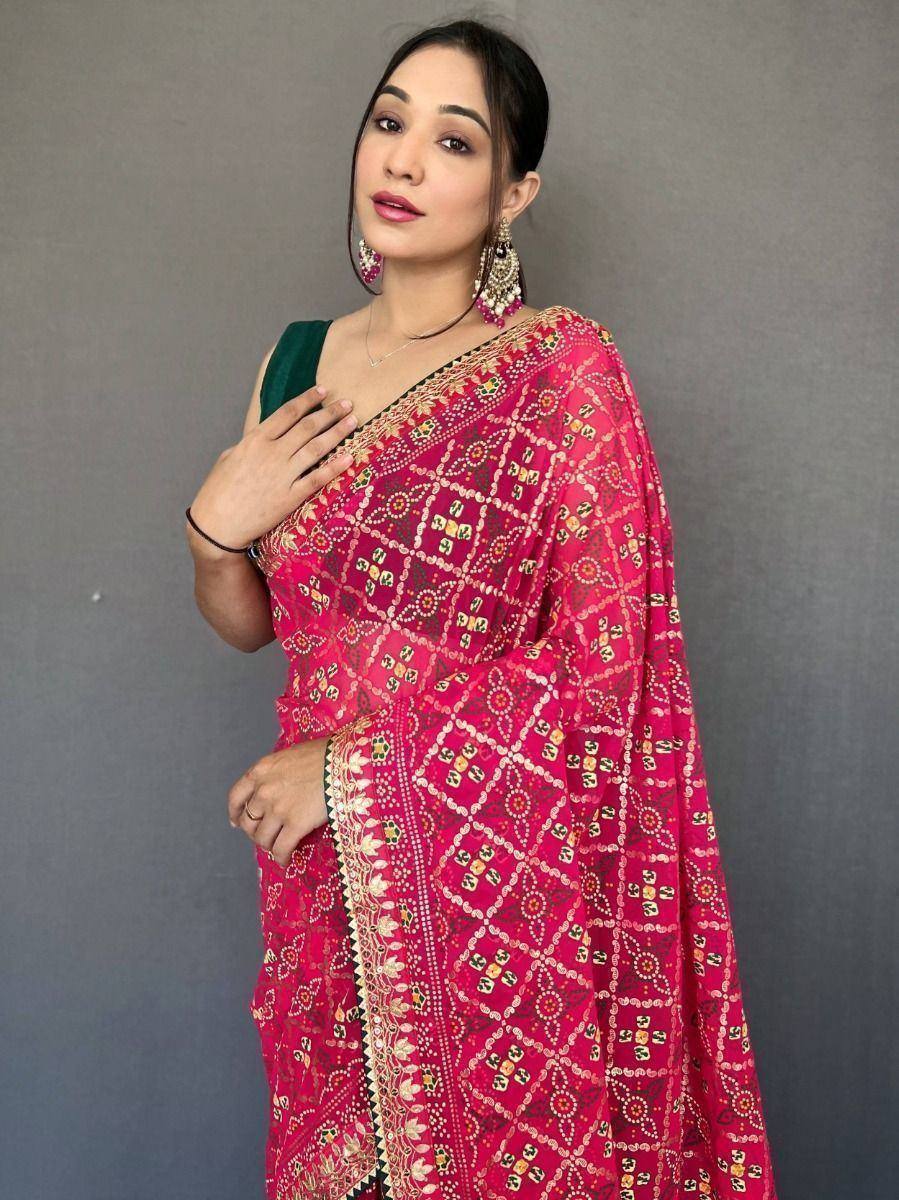 Woman in vibrant pink printed saree with green blouse, ethnic Indian wear