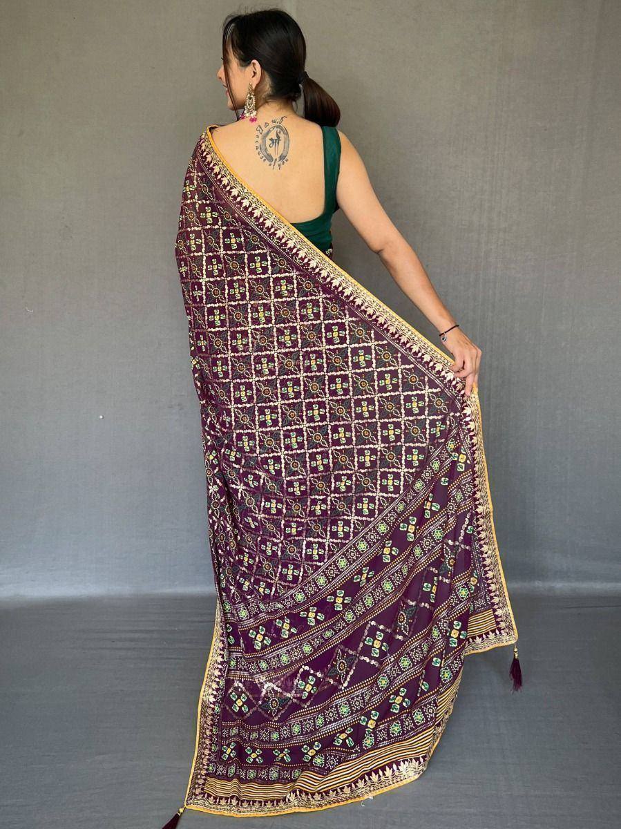 Woman wearing purple printed saree with gold border, ethnic Indian wear for festive occasions