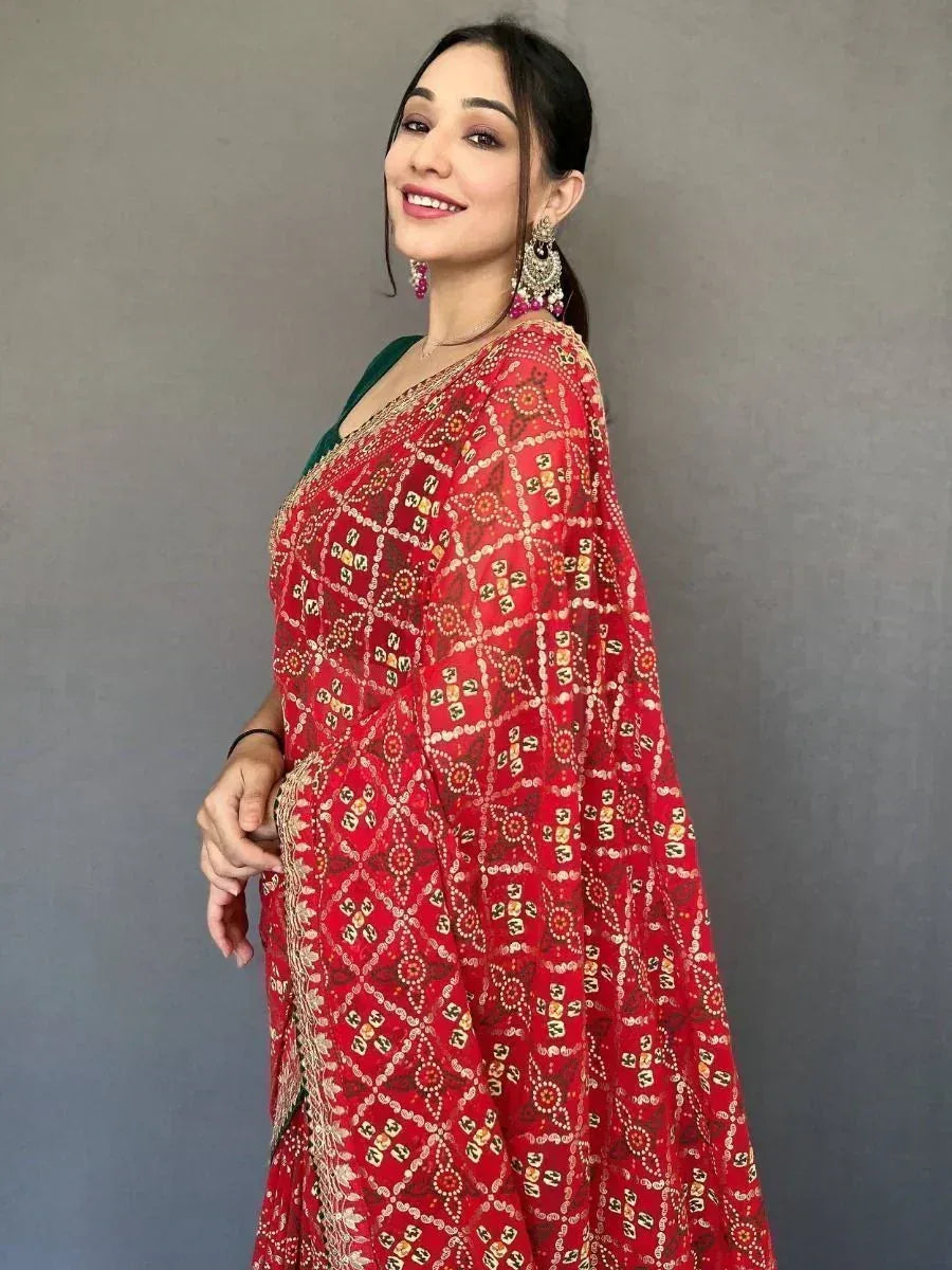 Woman in red printed saree with gold embroidery, green blouse, and statement earrings