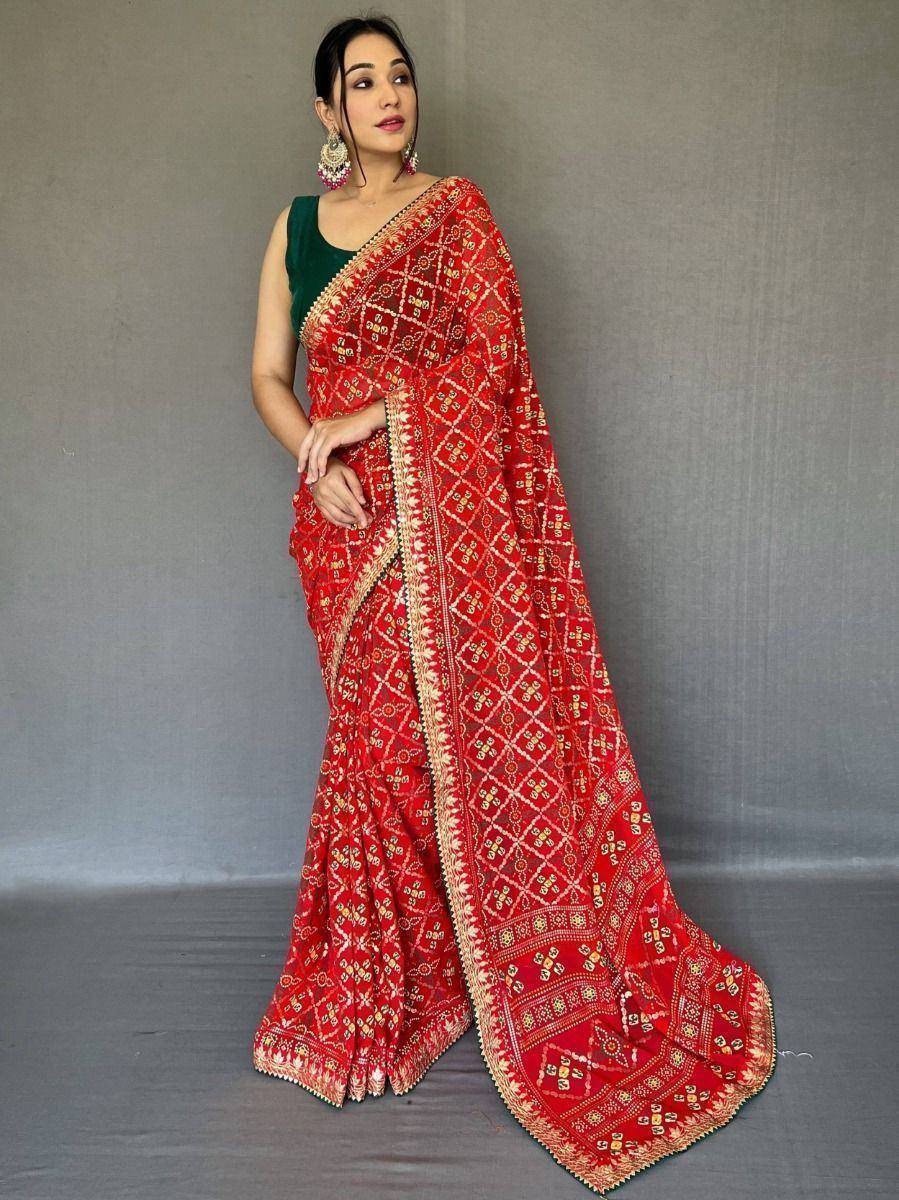 Red embroidered saree with gold patterns, paired with green blouse, ideal for Indian ethnic wear occasions