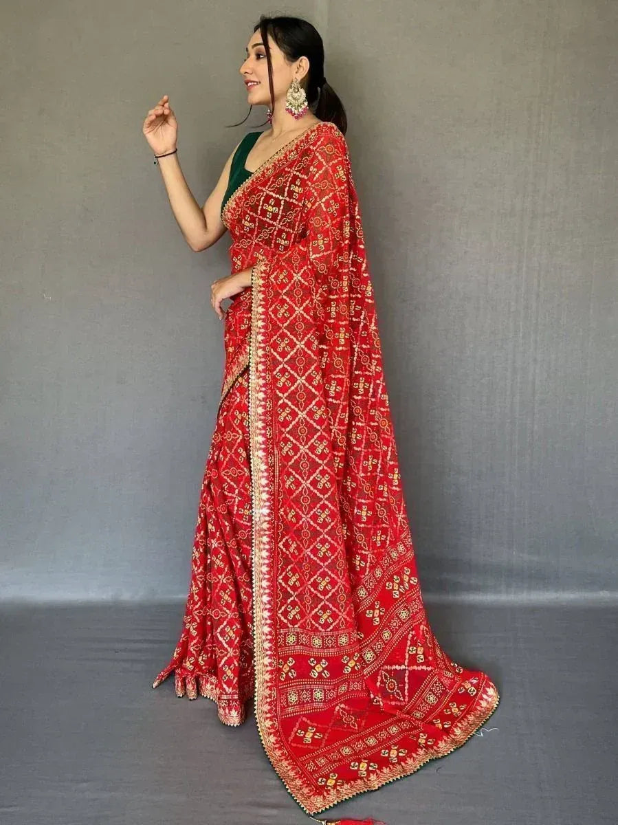 Red embroidered saree with gold patterns, paired with green blouse, perfect for Indian ethnic occasions