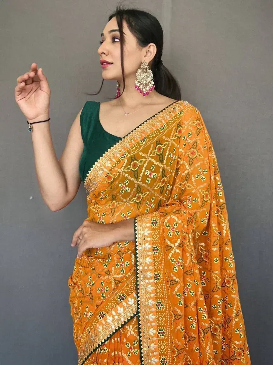 Woman in vibrant orange printed saree with green blouse, ethnic Indian wear for festive occasions