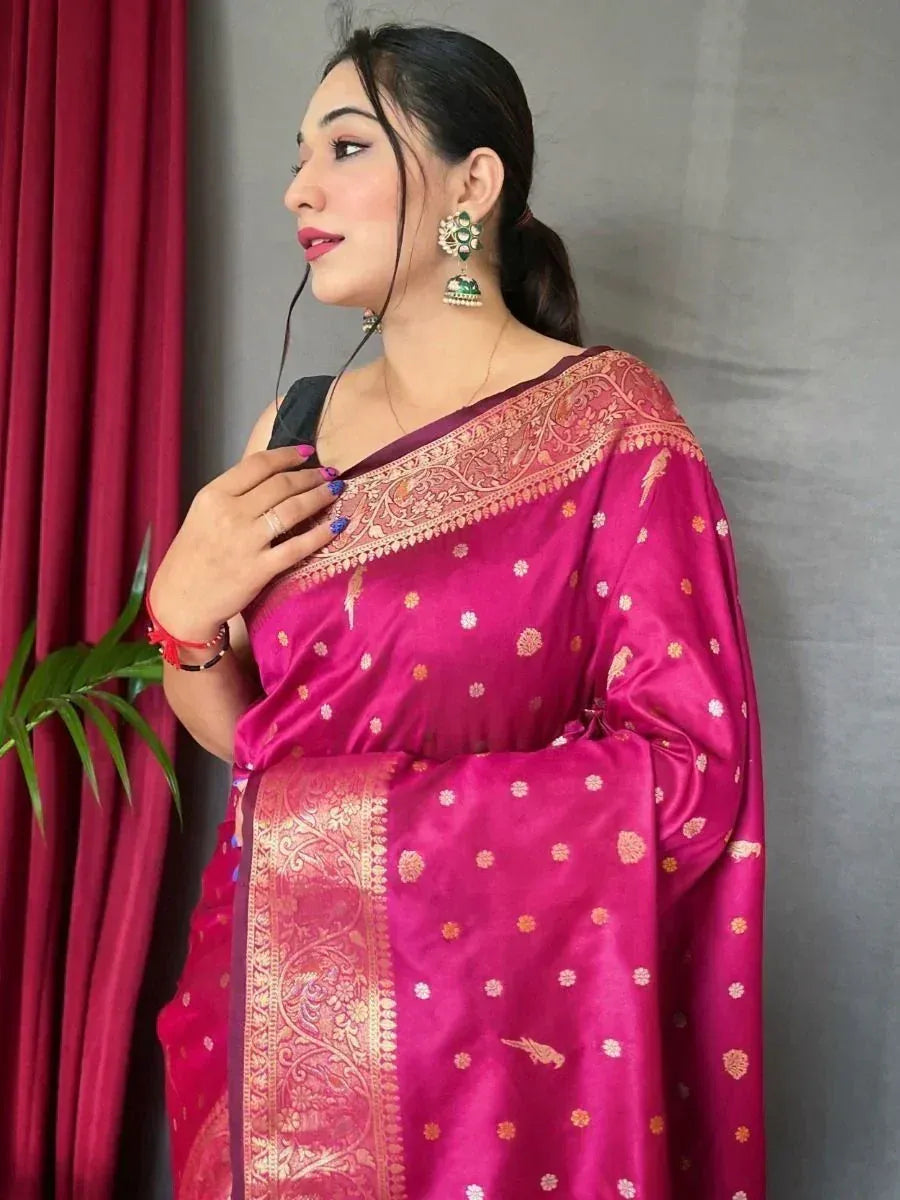 Pink designer saree with gold floral motifs and embroidered border, paired with statement earrings
