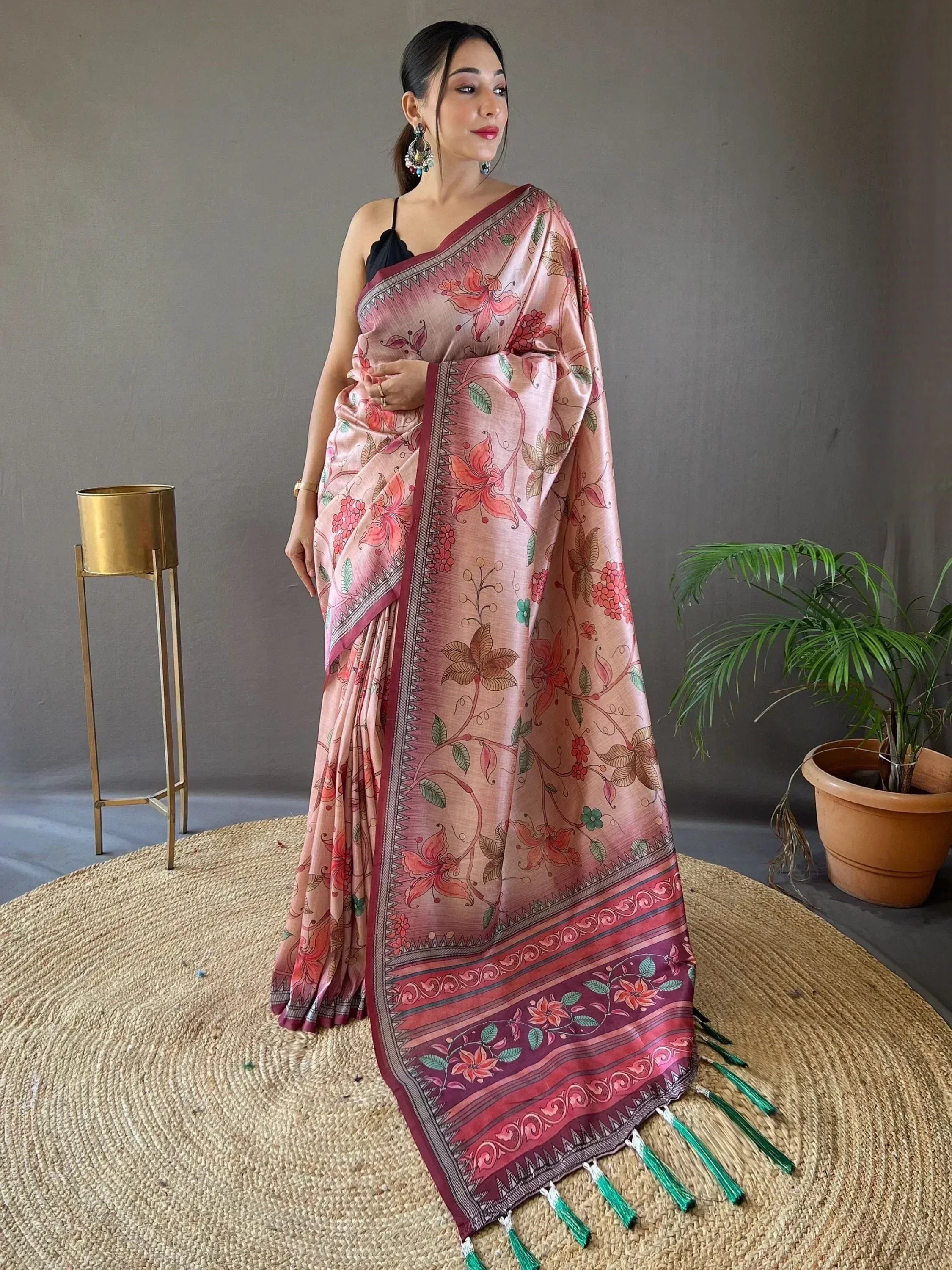 Pink floral printed saree with maroon border and green tassels, styled with black blouse for ethnic wear