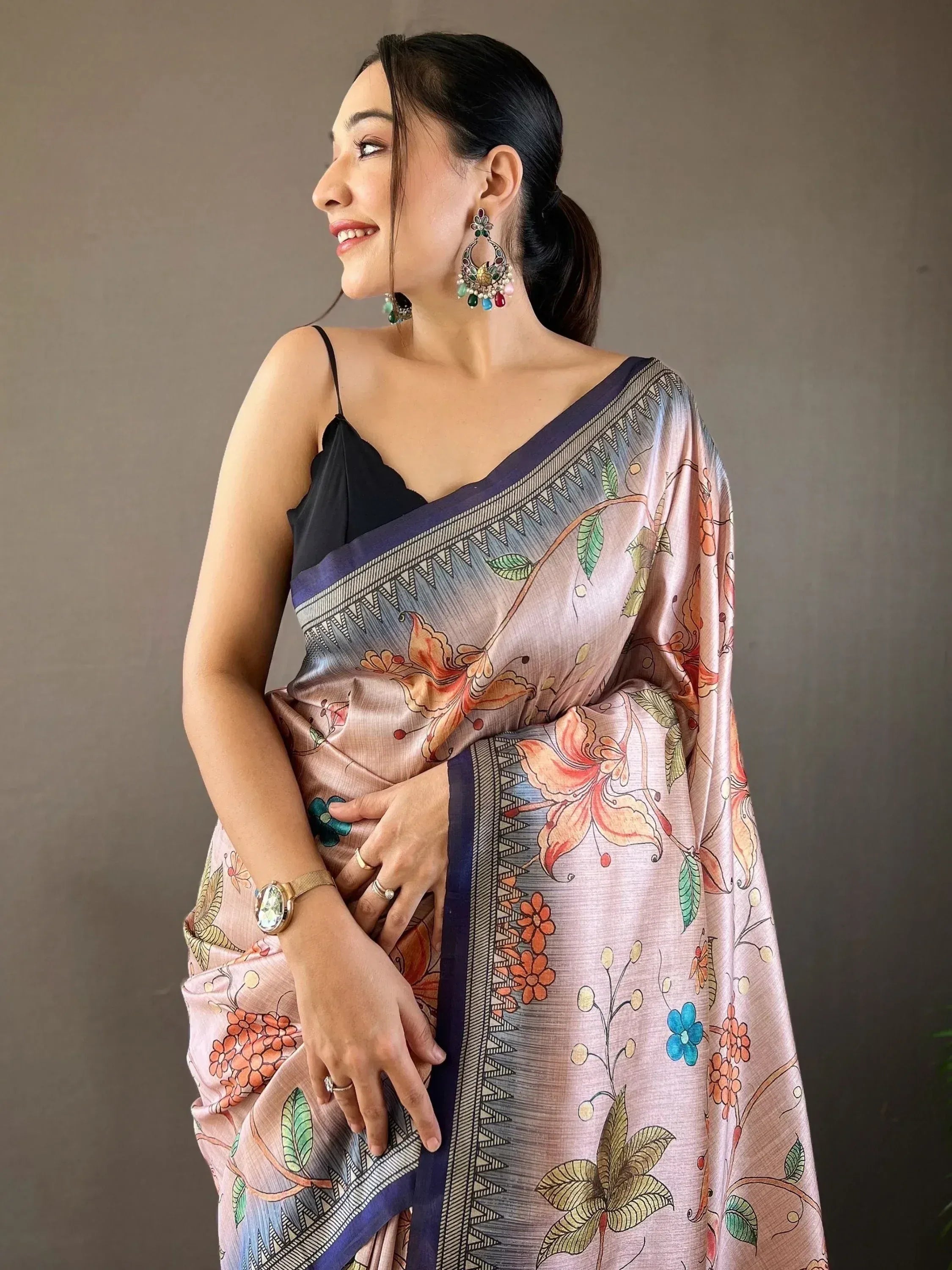 Woman in floral print saree with black blouse, ethnic jewelry, and elegant drape for Indian ethnic wear