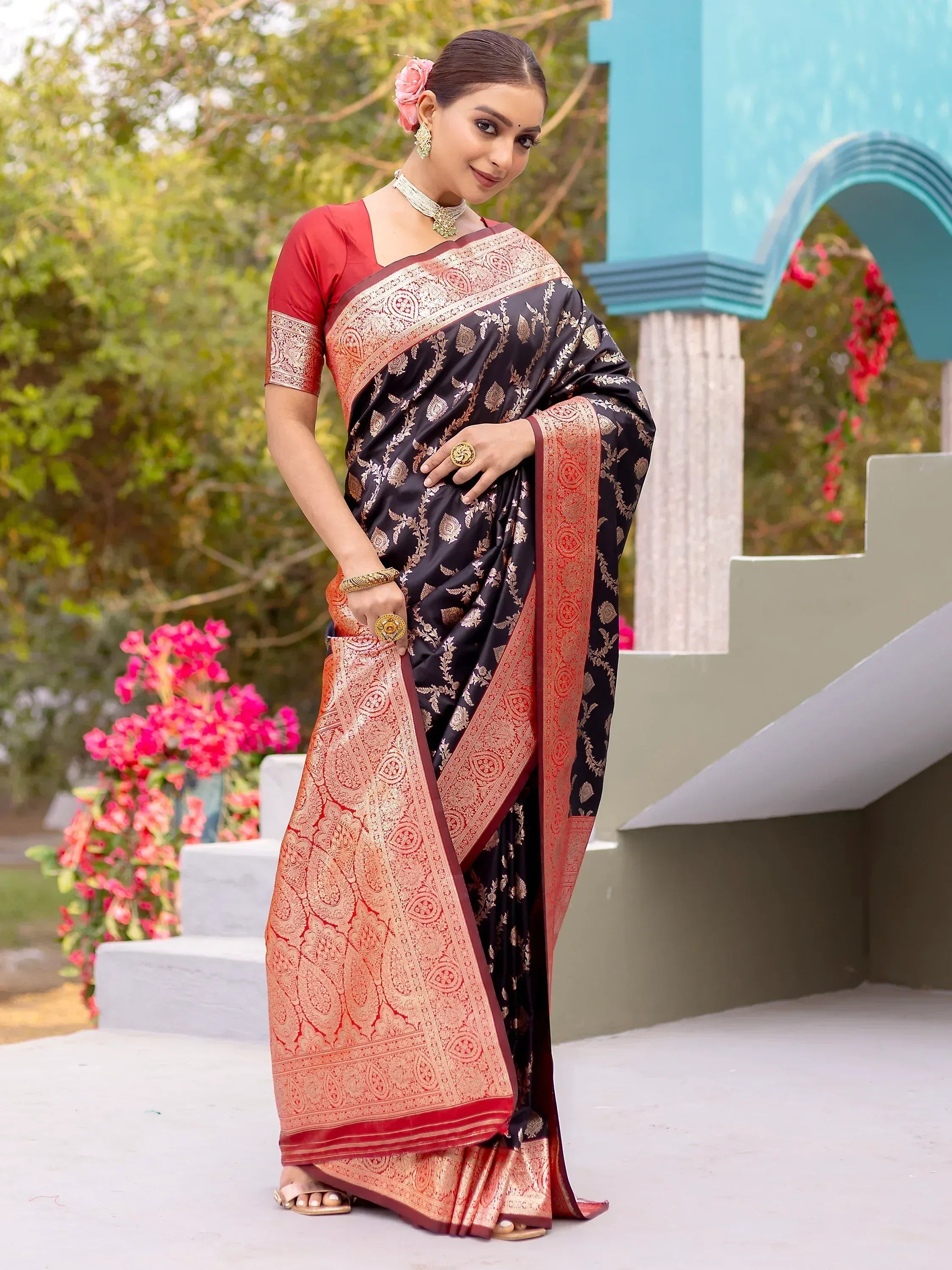 Elegant black and red saree with gold embroidery, paired with a red blouse, perfect for Indian ethnic wear.