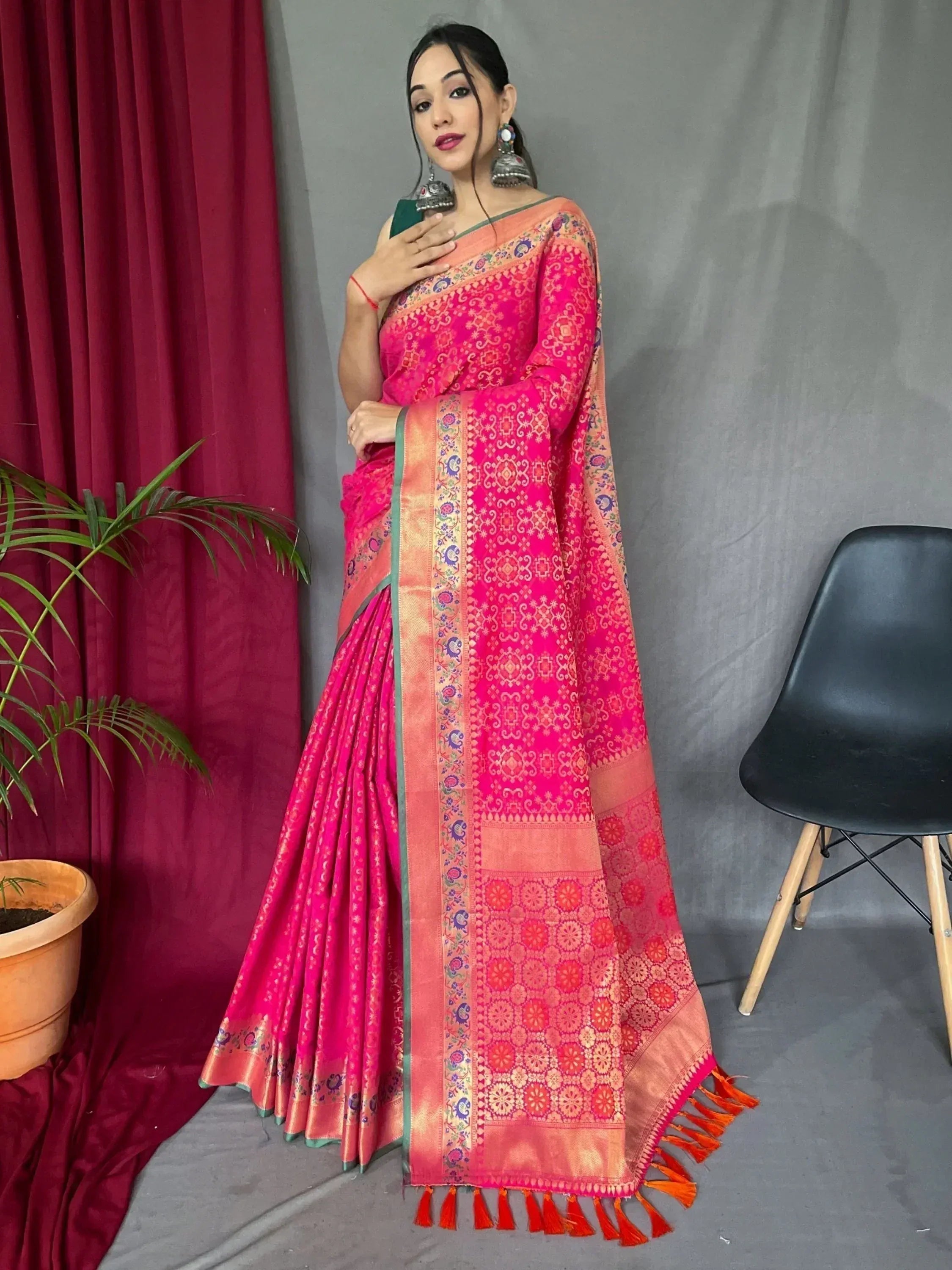 Vibrant pink ethnic saree with intricate gold patterns and tassels, perfect for Indian occasions