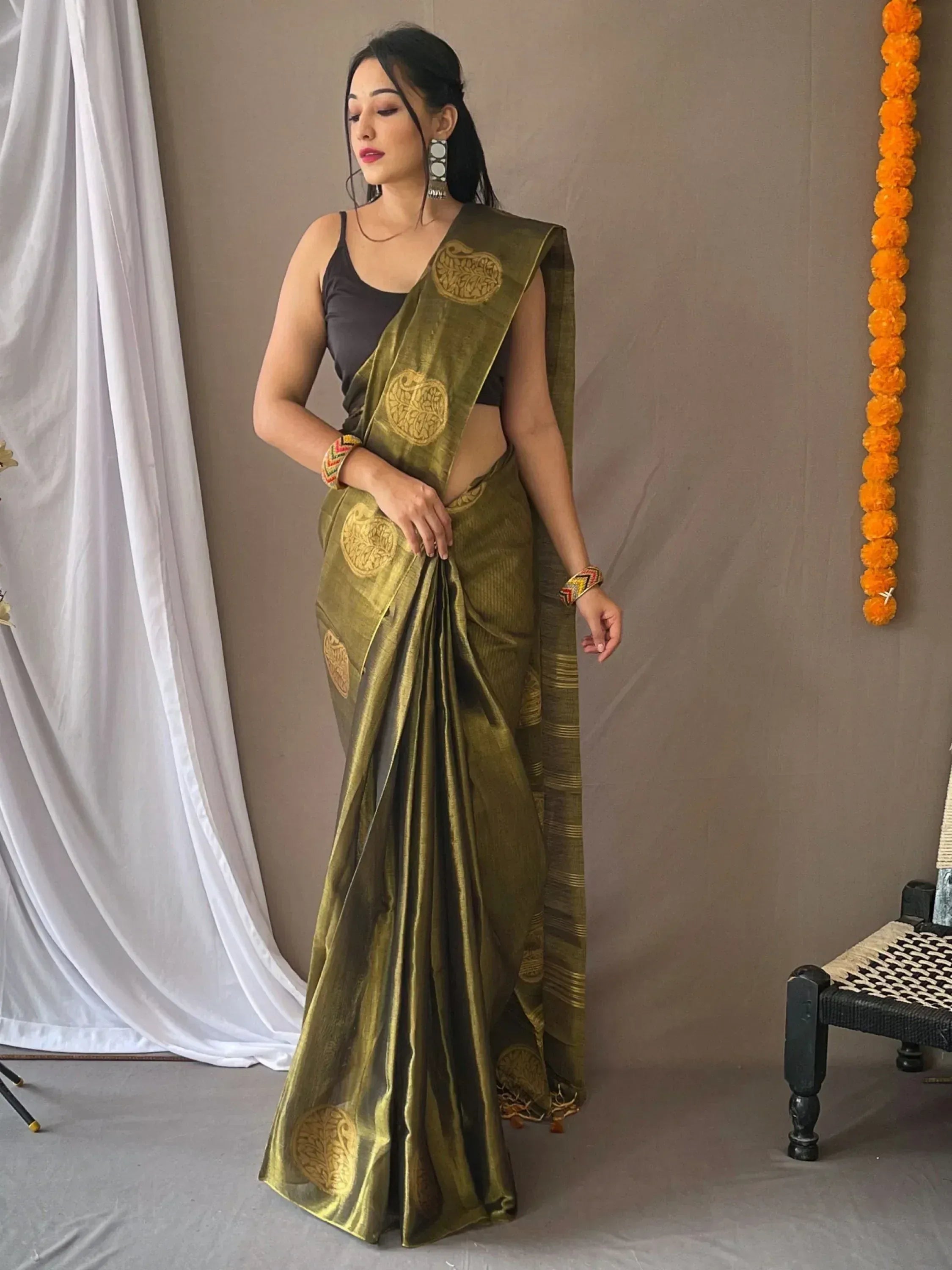 Olive green designer saree with gold circular motifs, paired with black blouse for ethnic wear
