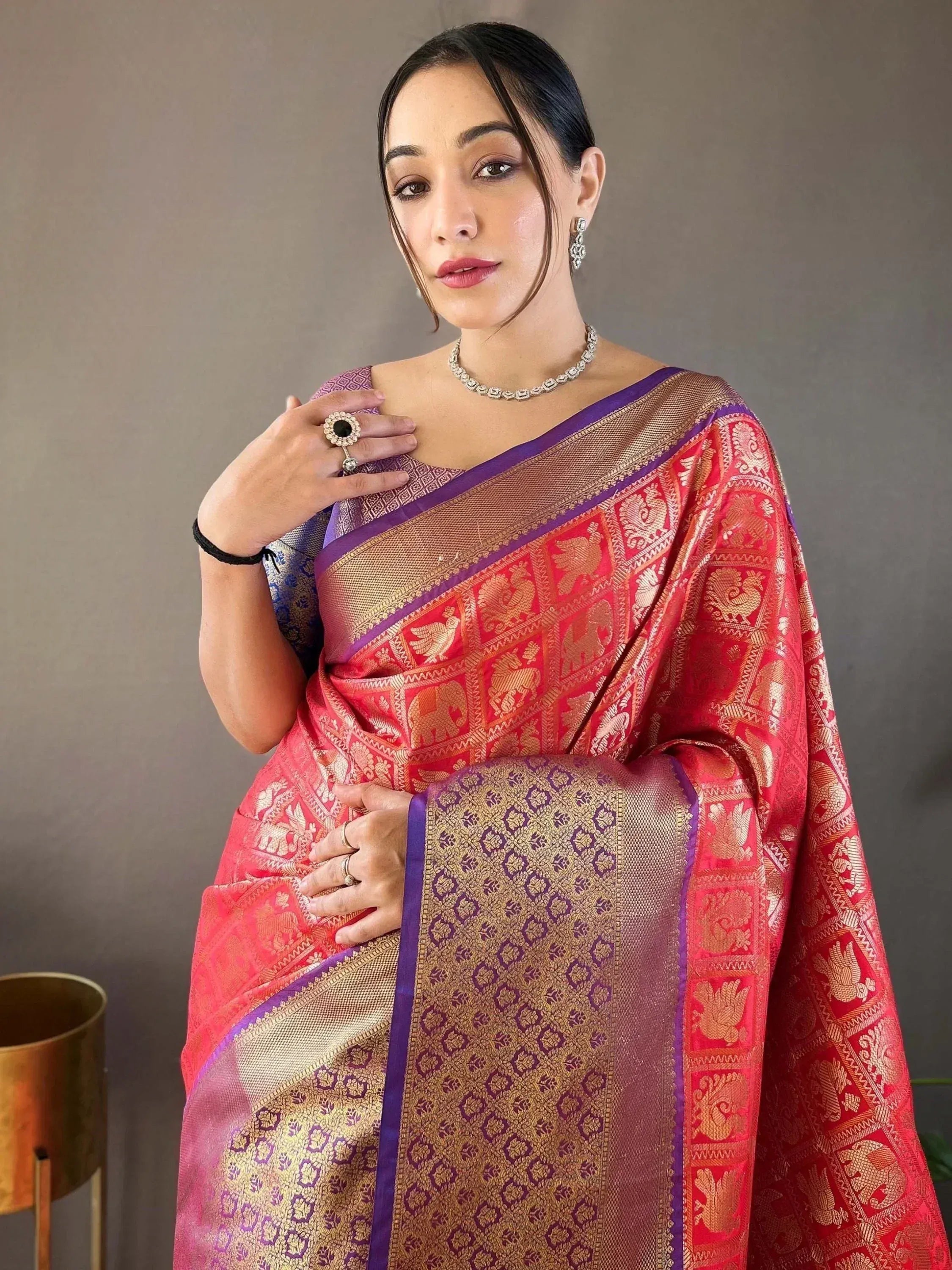 Woman in red and purple Banarasi saree with gold elephant motifs, ethnic Indian wear