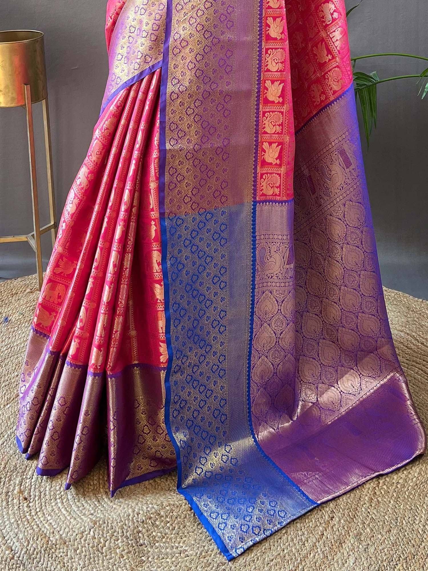 Pink and purple designer silk saree with gold zari elephant and peacock motifs, perfect for weddings