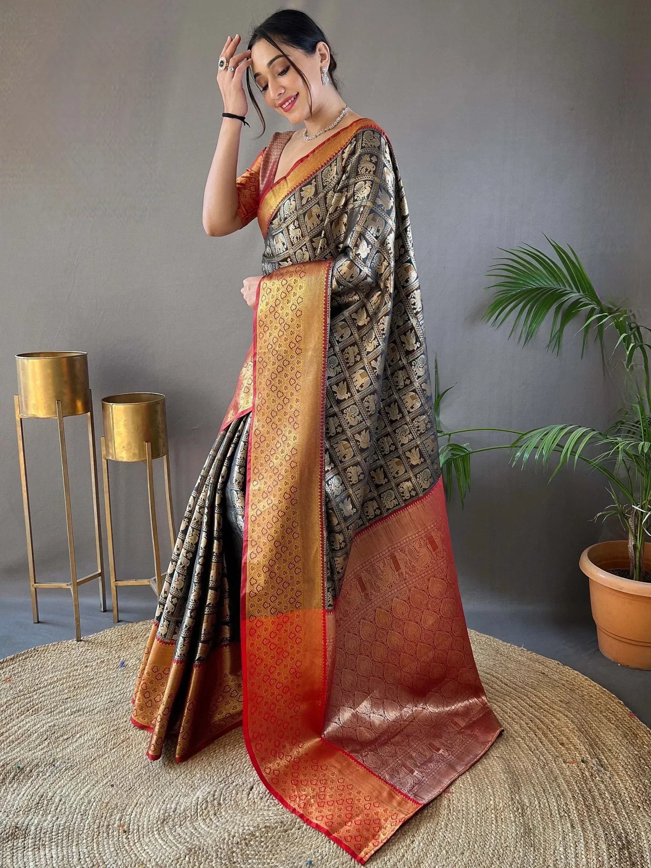 Elegant black and gold saree with intricate elephant motifs and vibrant red border, perfect for festive occasions.