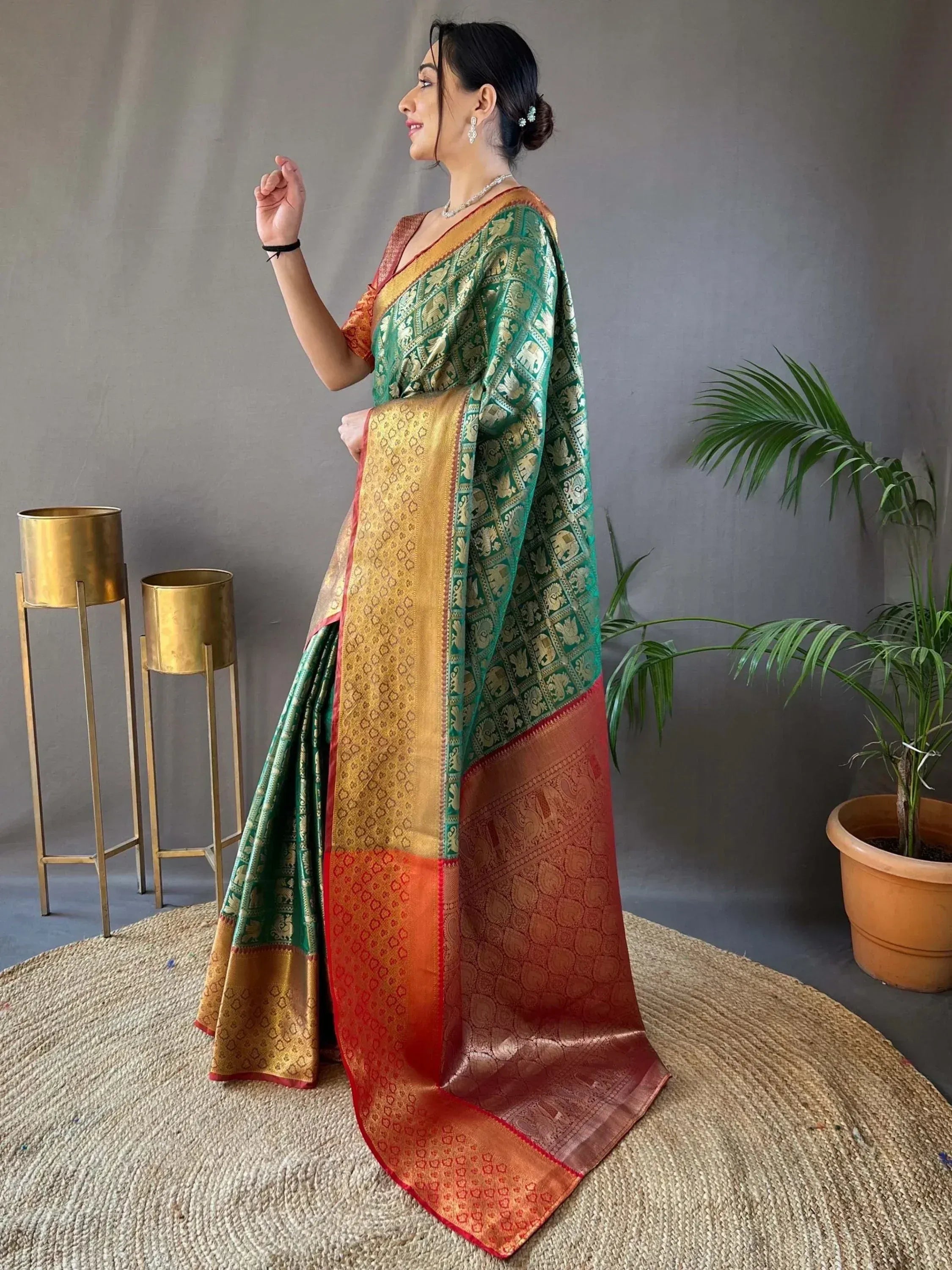 Woman in green and gold designer saree with elephant motifs, perfect for Indian ethnic wear occasions.