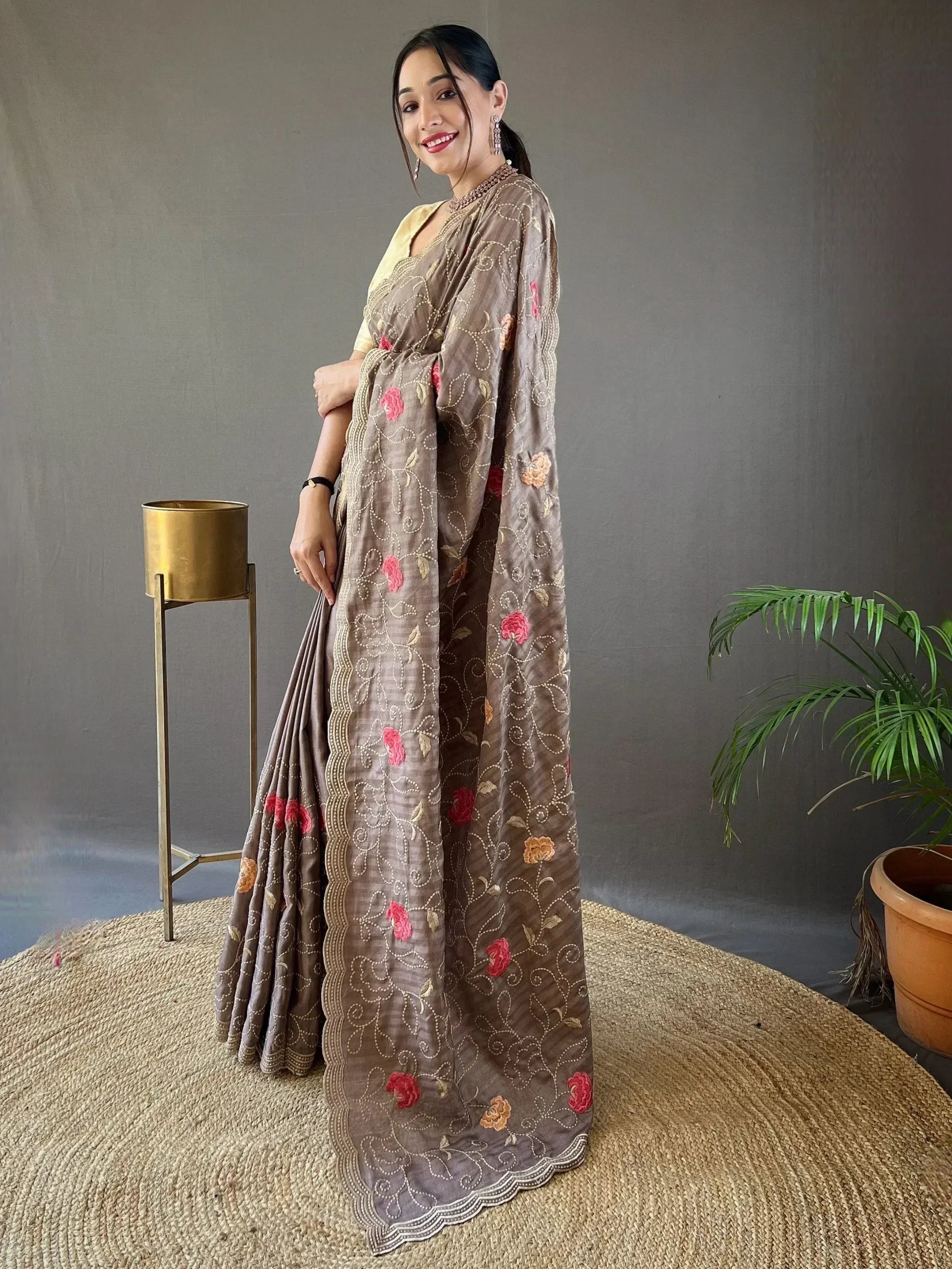 Brown embroidered saree with floral motifs and gold detailing, paired with yellow blouse for ethnic wear