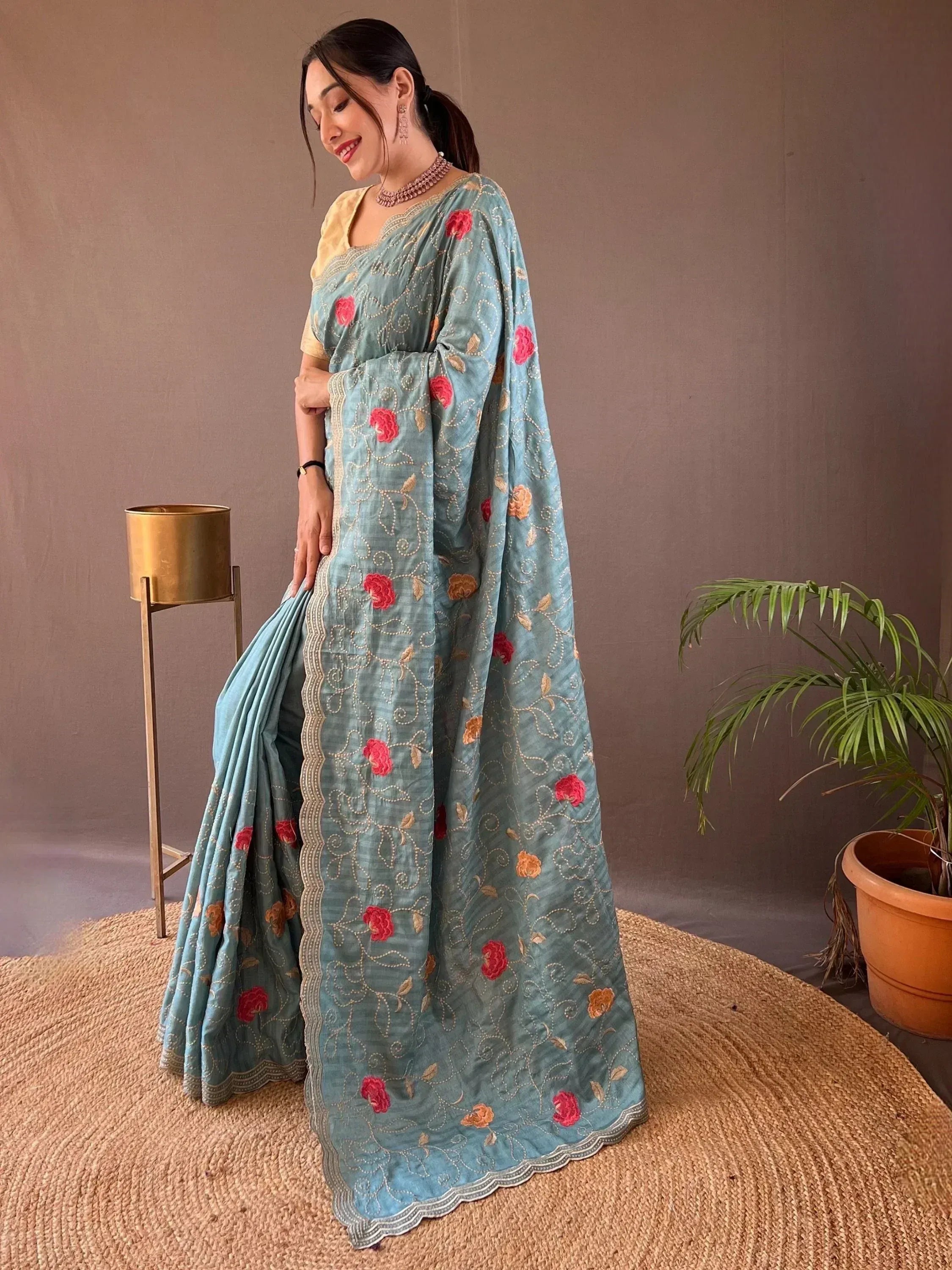 Woman in blue floral embroidered saree with gold detailing, styled for Indian ethnic wear occasions