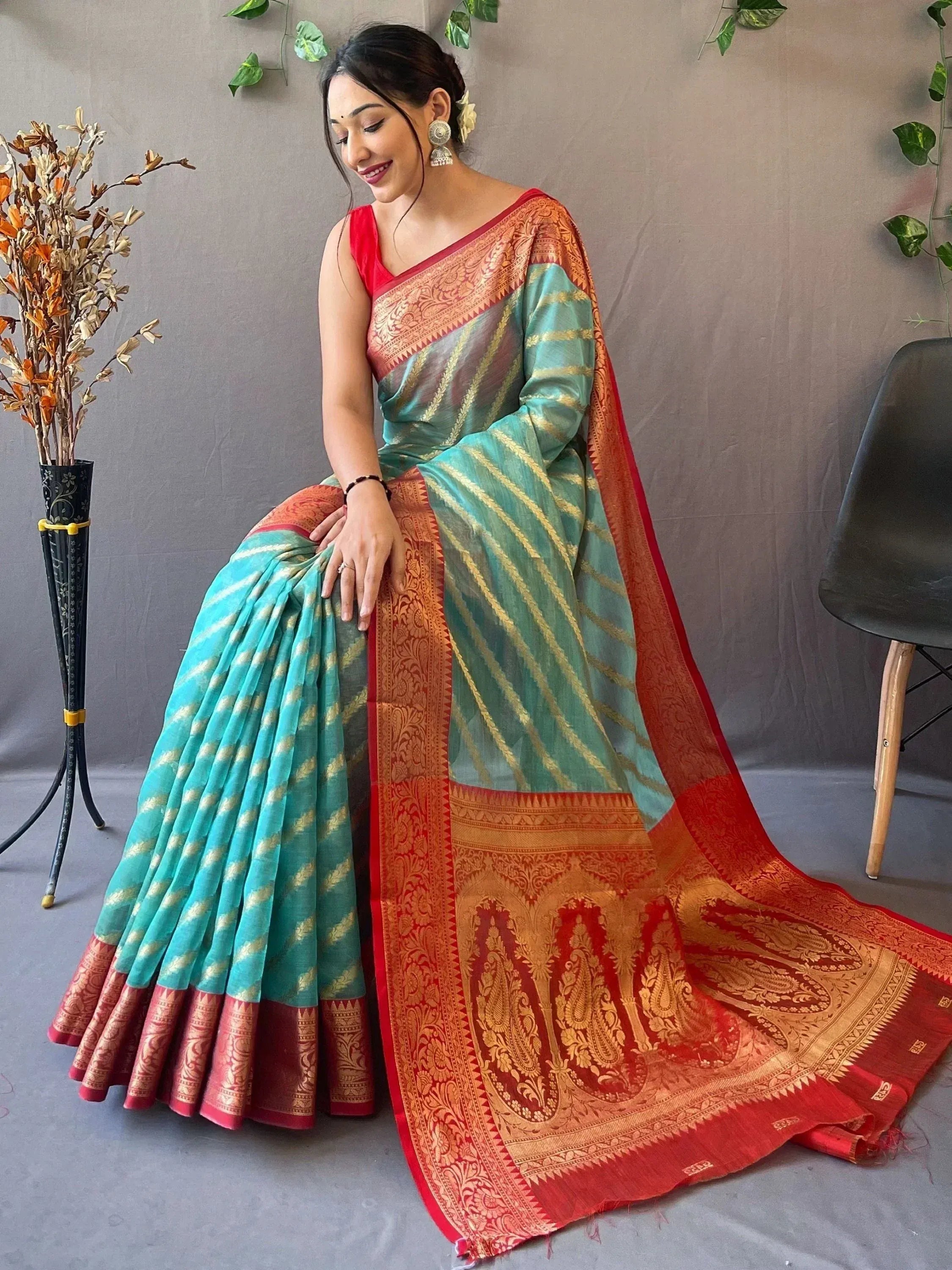 Teal and red designer saree with gold zari stripes and intricate border, perfect for ethnic occasions.