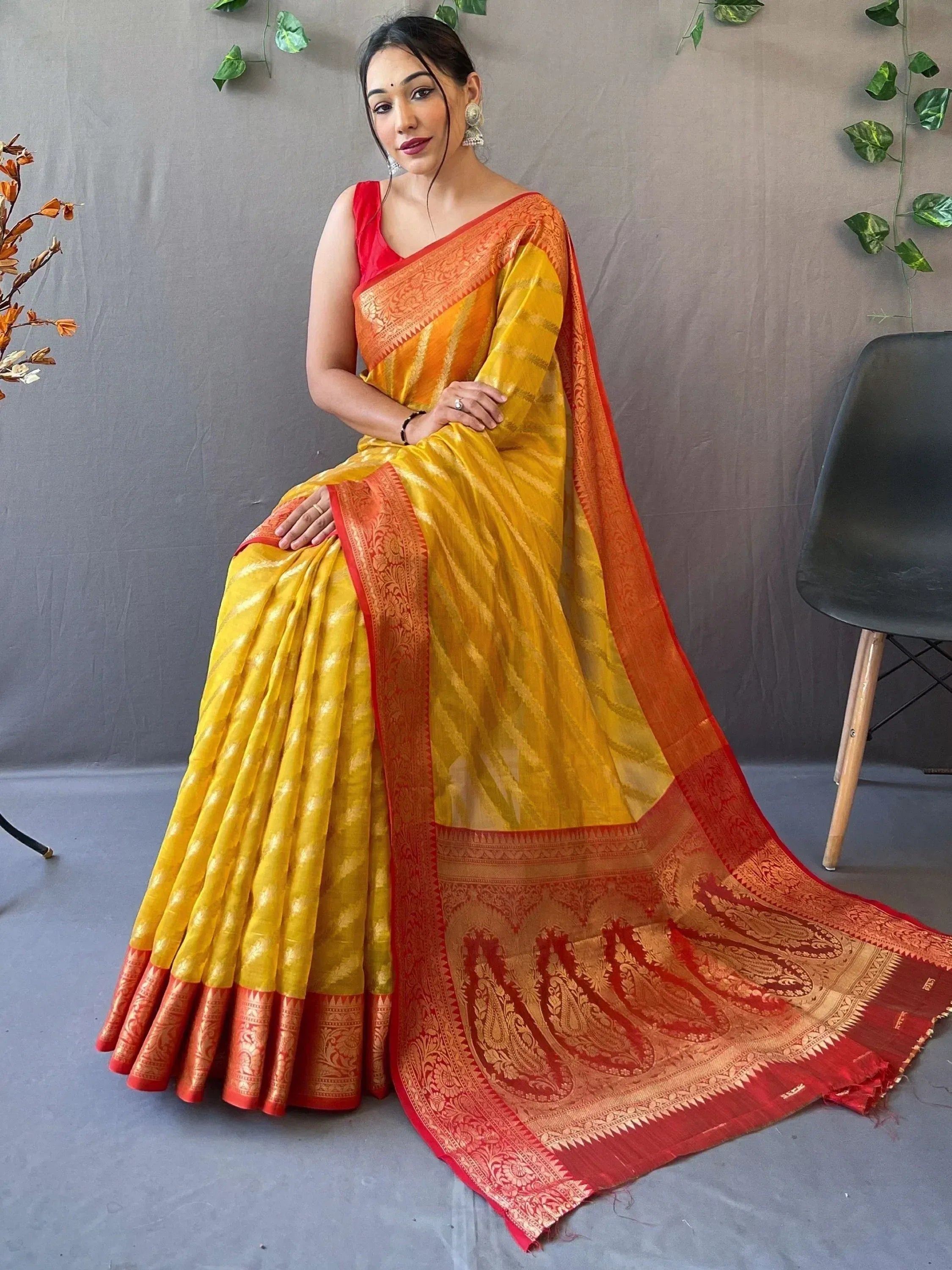 Yellow and red designer saree with intricate paisley border, perfect for ethnic occasions