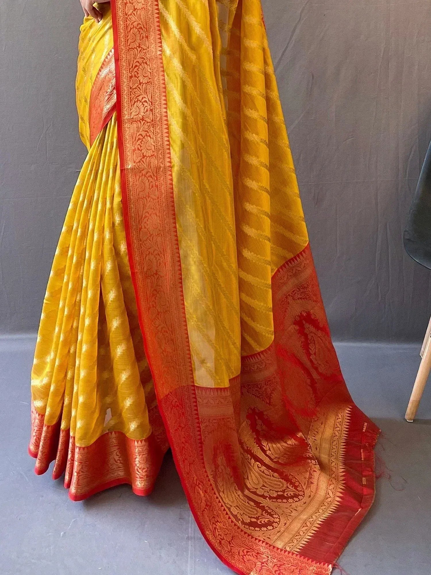 Yellow and red designer saree with intricate paisley border, perfect for ethnic occasions
