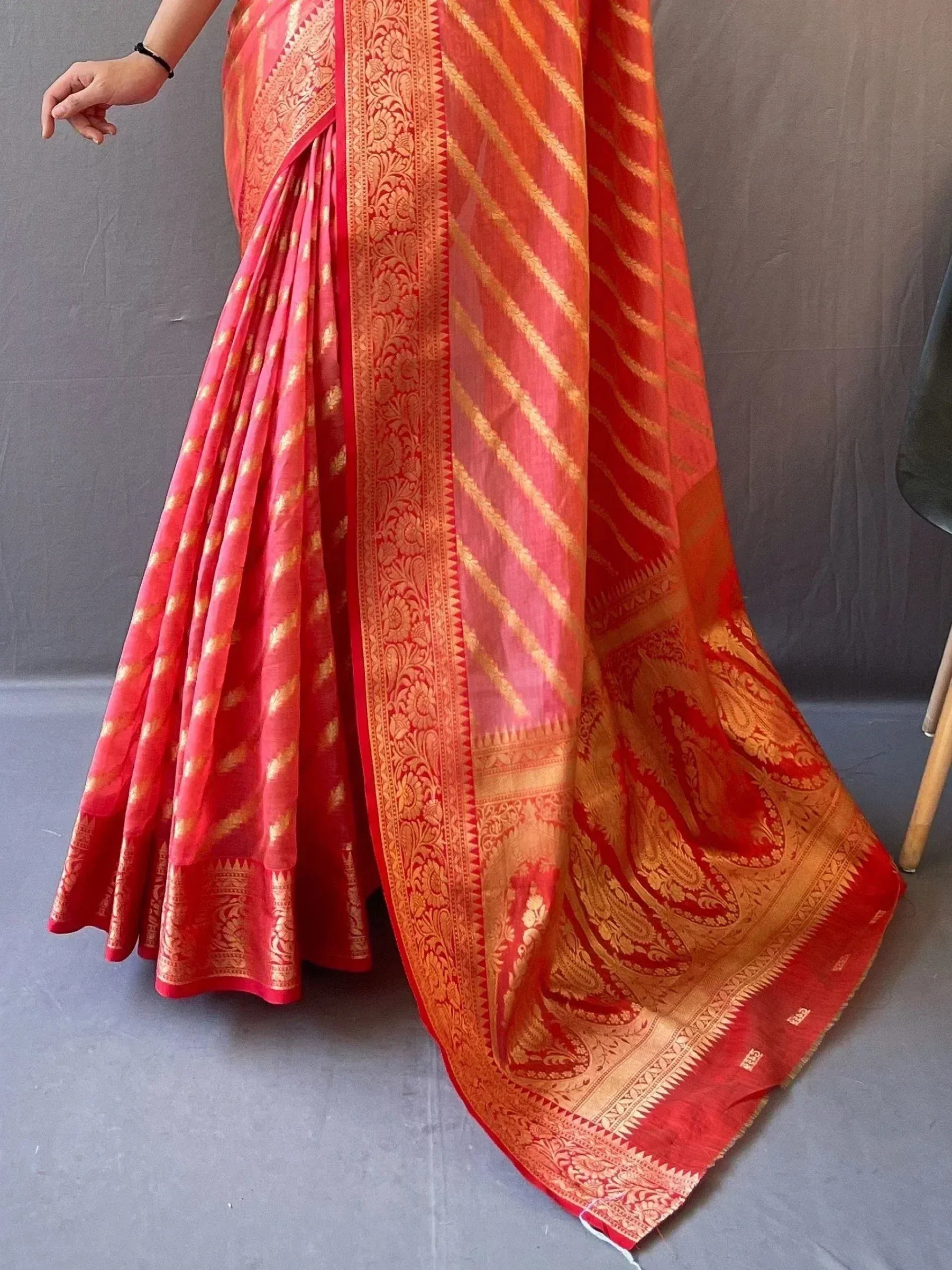 Red and gold designer saree with intricate paisley and striped patterns, perfect for ethnic occasions