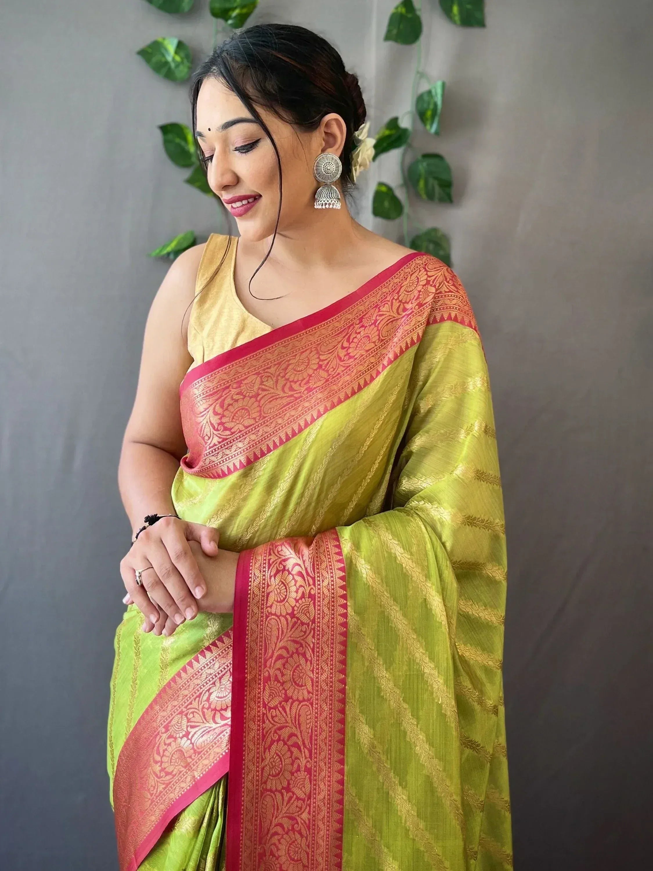 Woman in vibrant green and pink ethnic saree with gold blouse, perfect for Indian occasions