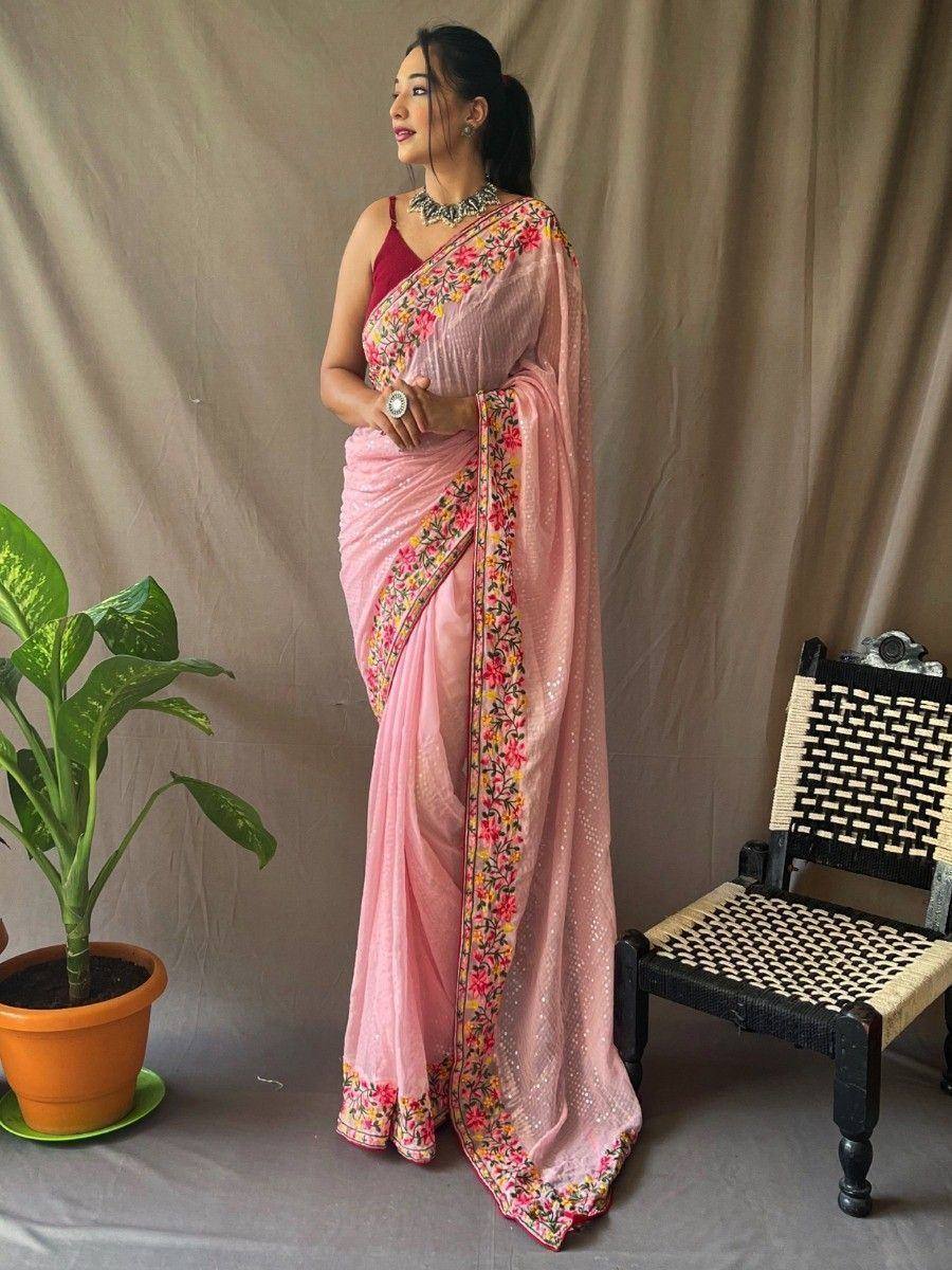Pink floral saree with embroidered border, paired with red blouse and statement jewelry