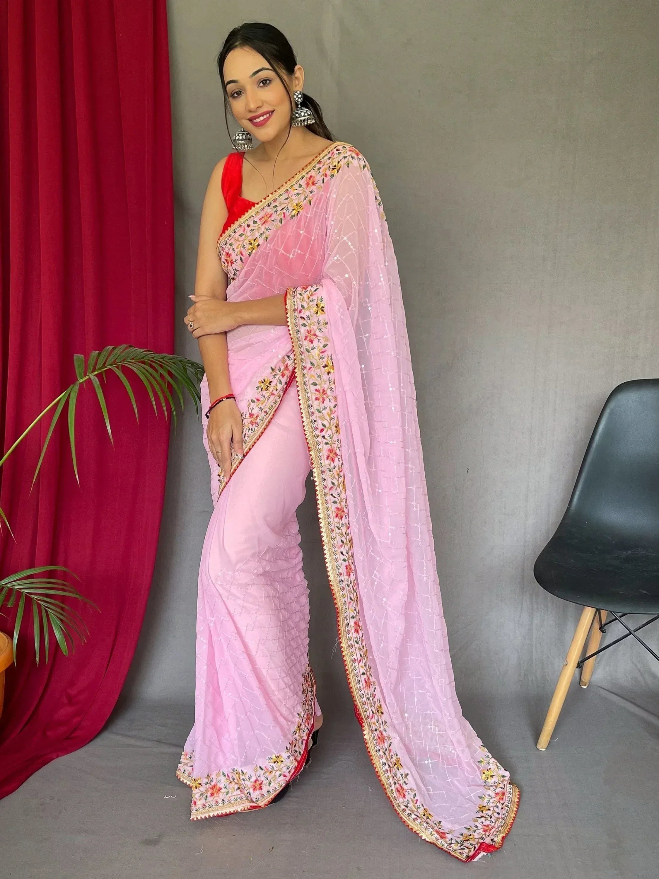 Pink embroidered saree with red blouse, floral border, and sequin detailing for Indian ethnic wear